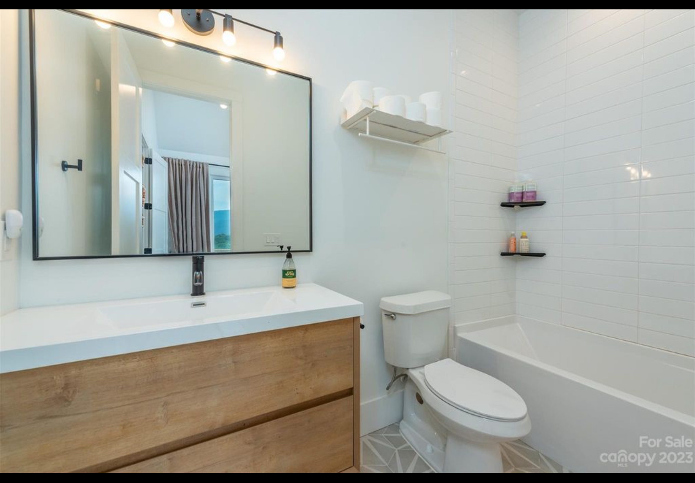 Bathroom with floating vanity. Fiberglass tub with subway tile straight stack pattern to ceiling.