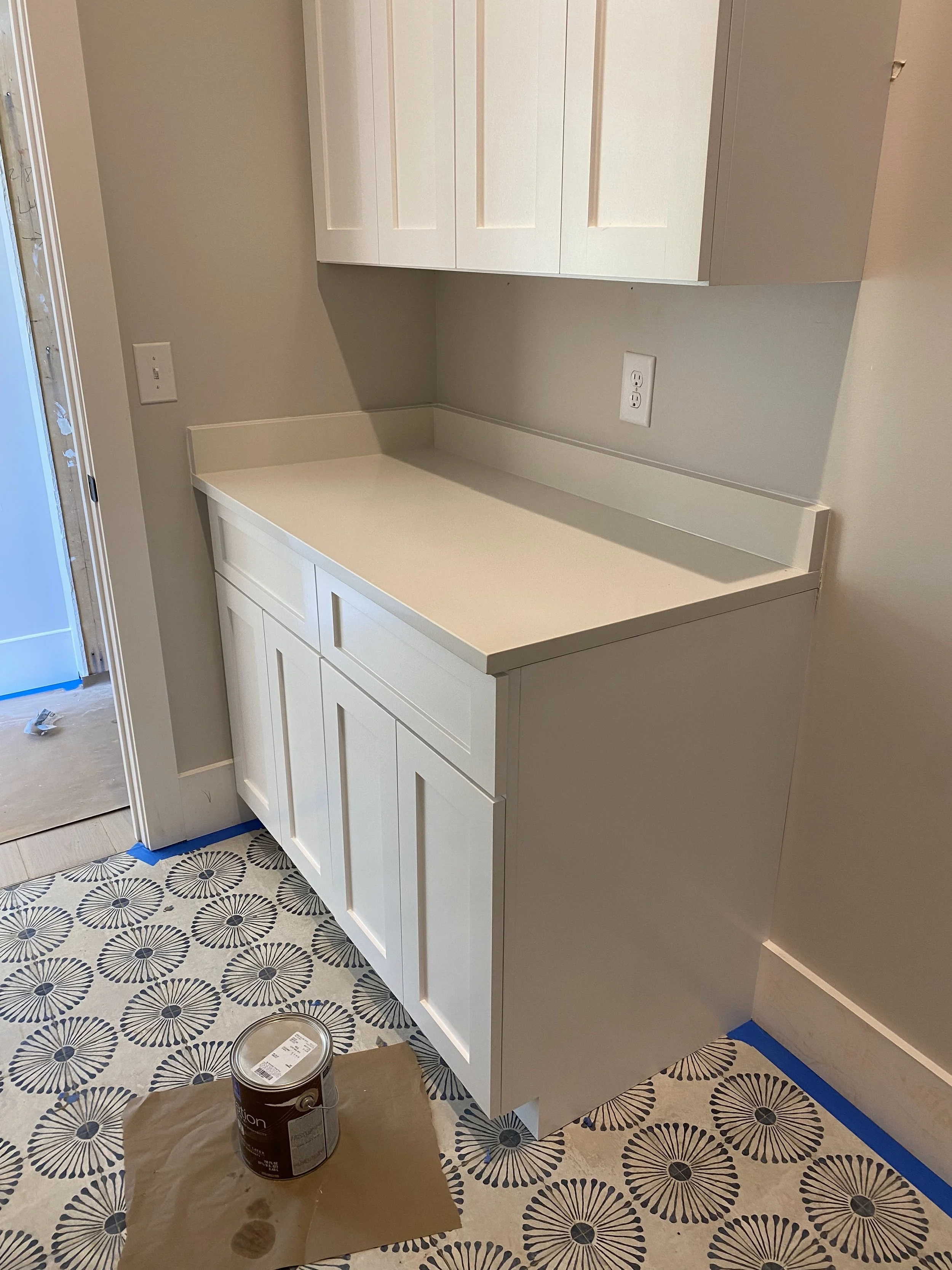 Custom Laundry room cabinetry with Quartz top and decorative pattern floor tile.