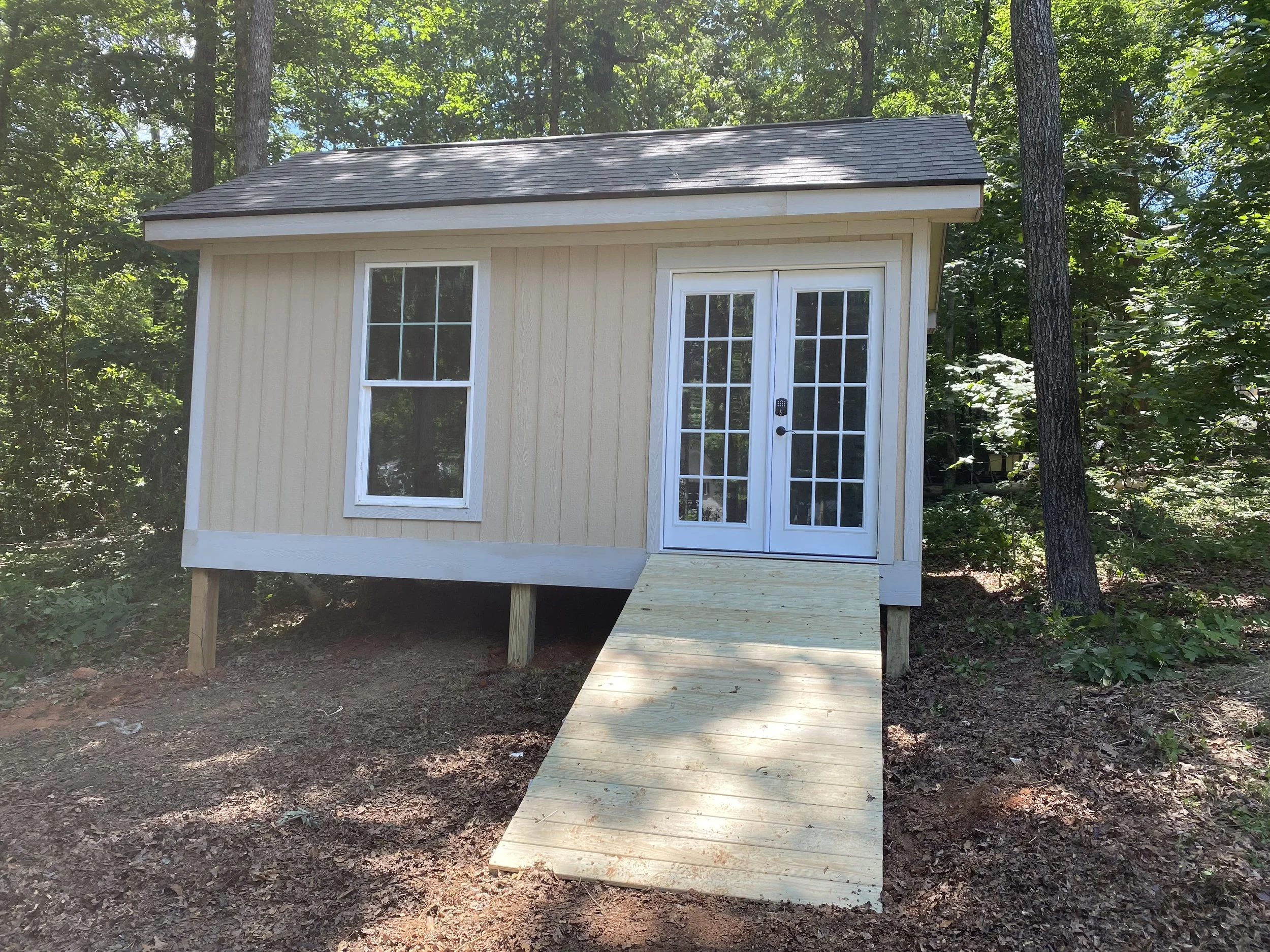 Small storage shed with bi hinge french doors, and vinyl windows. Wood ramp to access.