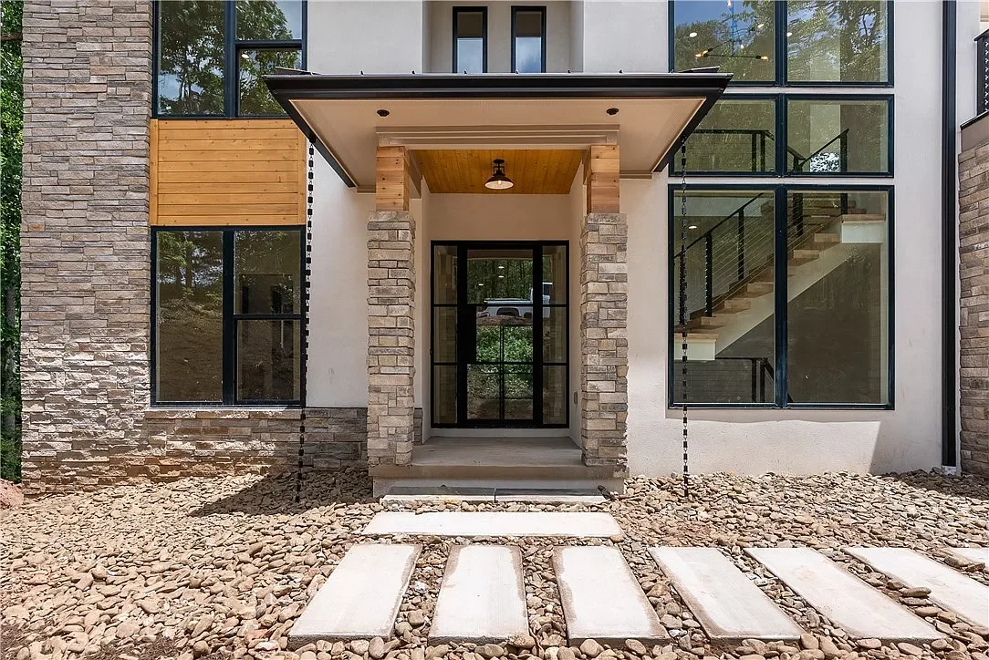 Black Diamond iron entry door with sidelights. Custom entry columns. Rain chains. Poured concrete step path.