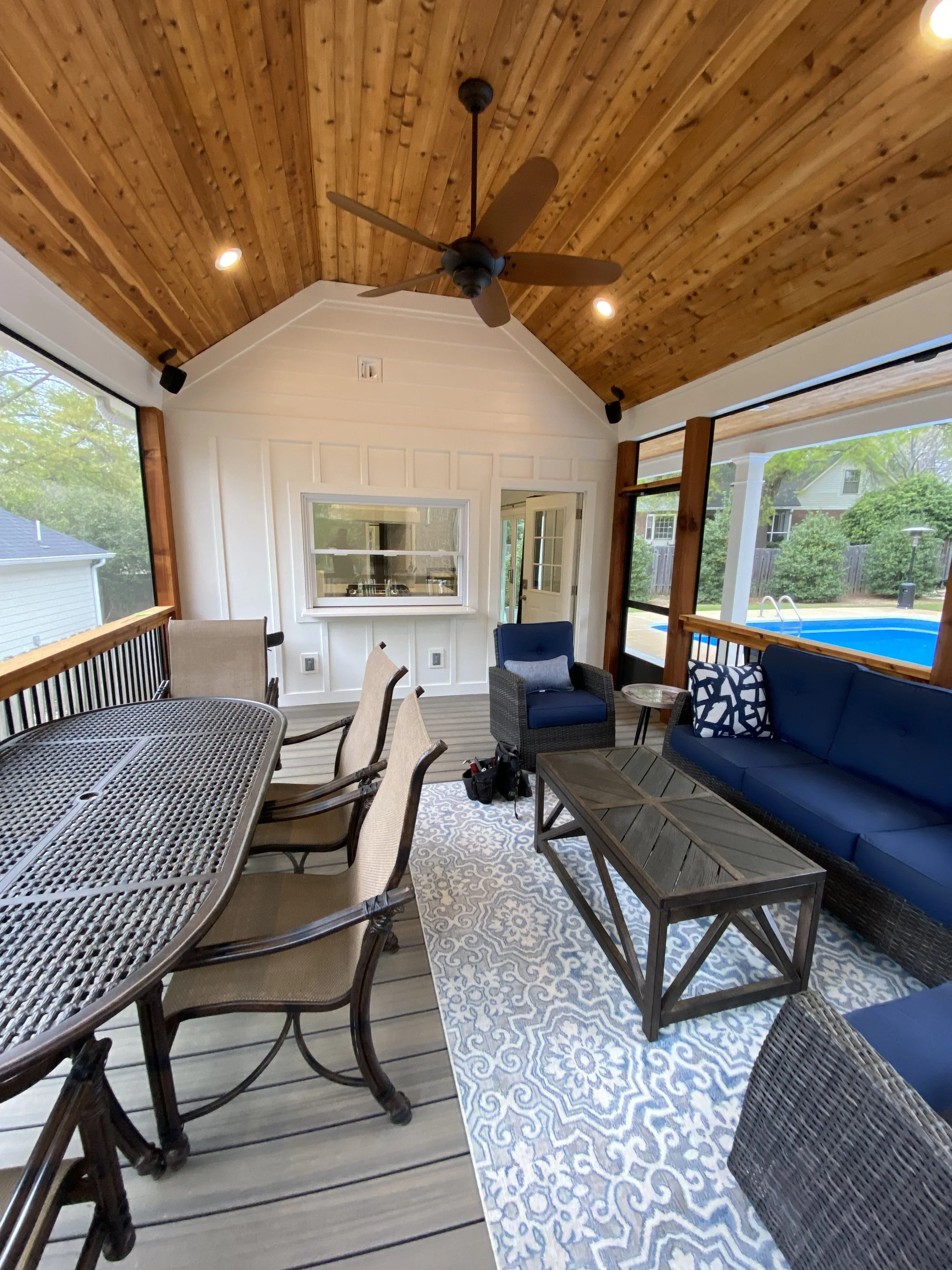 Detached pool house private screened in porch. Screen-Eze screen system installed on outside of cedar handrails with aluminum balusters. Aluminum screened door. Vaulted cedar tongue and groove ceiling. Fold up pass through window.