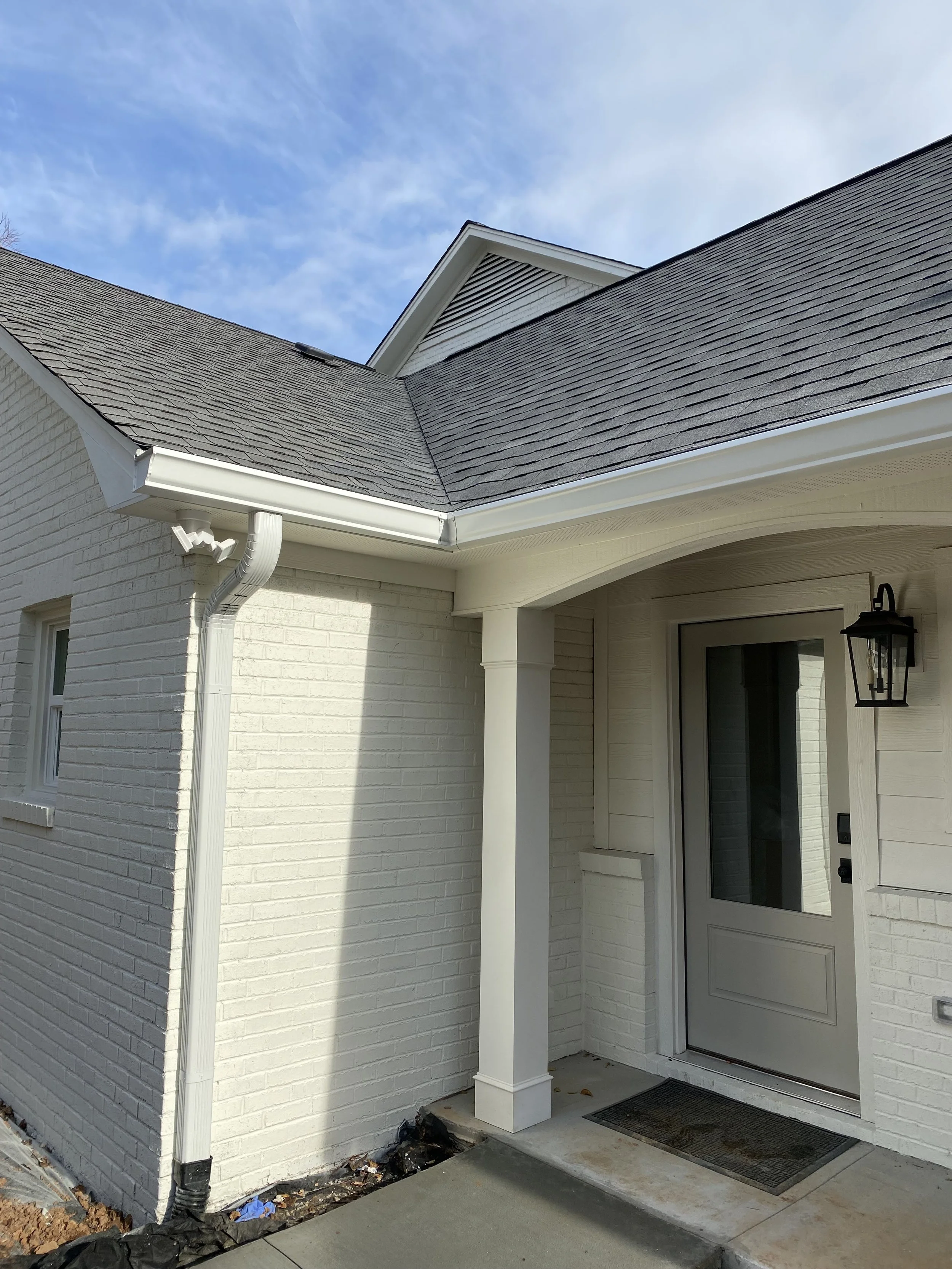 Large attached garage with fiber cement plank siding coming off of existing brick home. Custom arched header with decorative support posts.