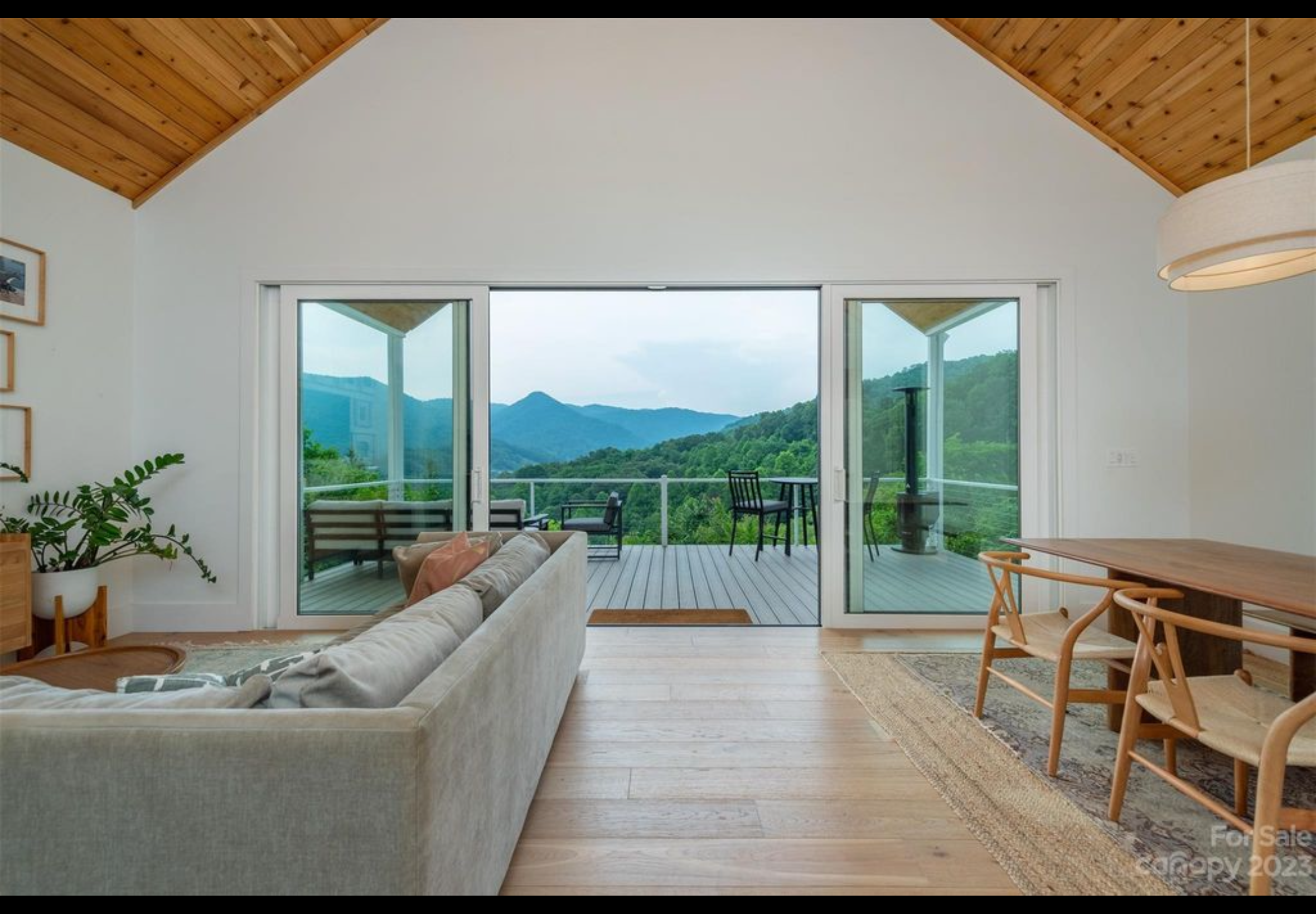 Finished interior of mountain getaway tiny home. PGT bi parting vinyl sliding door opening out to Trex composite deck. LVP flooring with real wood top layer. Cedar tongue and groove on interior vaulted ceiling.