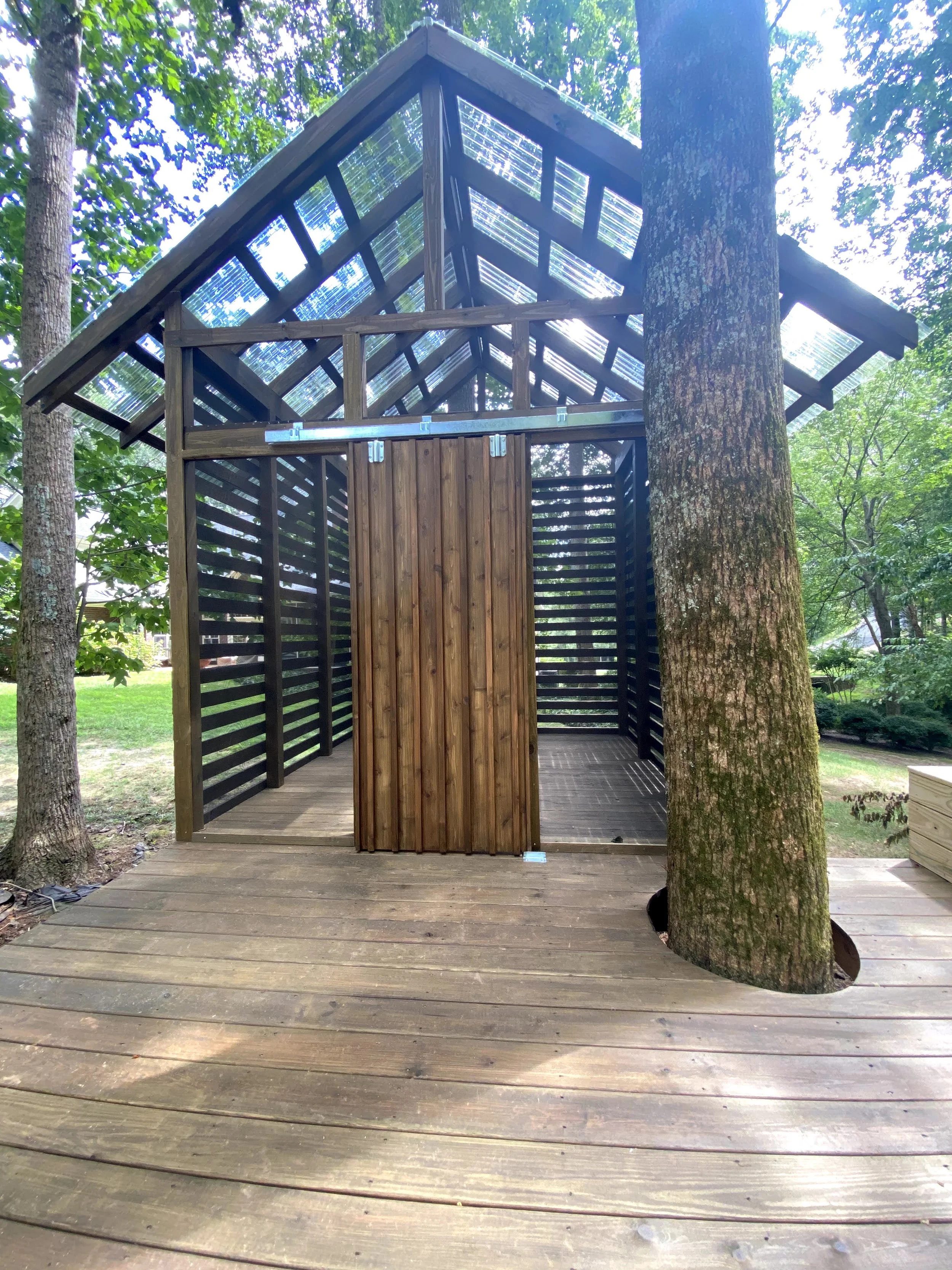Custom tree house deck. Clear roofing and custom sliding barn door.