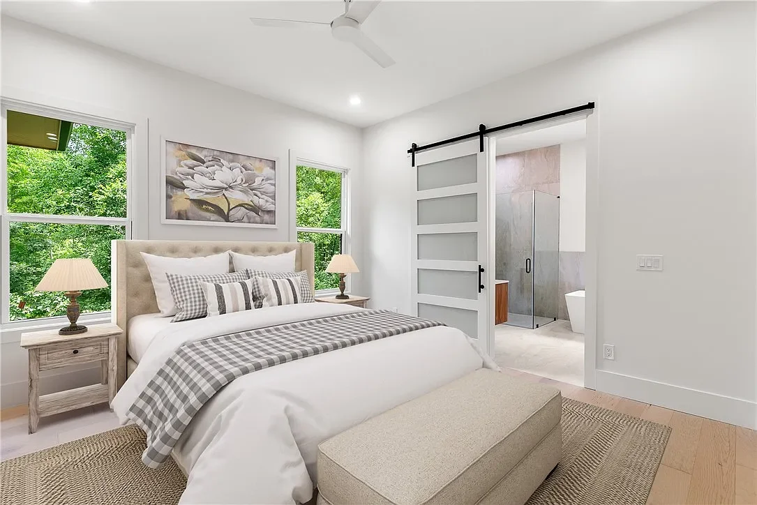 Wide plank LVP flooring. Minka Aire ceiling fan. 8' Tall frosted glass sliding barn door leading to primary bathroom.