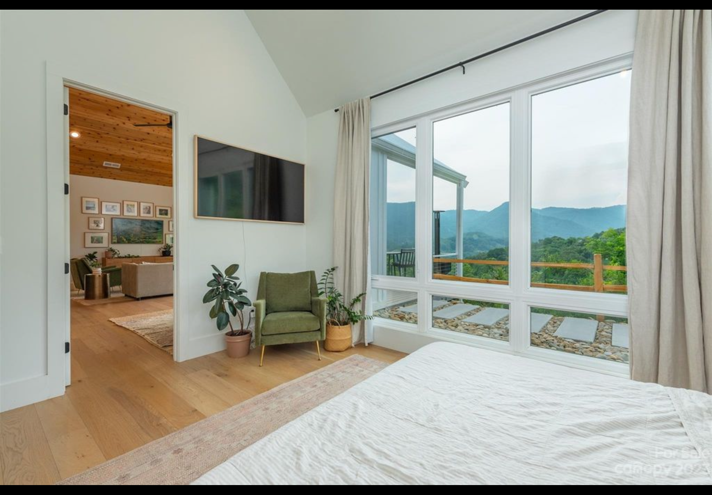 Bedroom one of two bedroom two bath tiny home mountain getaway. Vaulted ceiling. Vinyl casement windows with lower fixed transoms. LVP engineered hardwood flooring with real wood top layer.