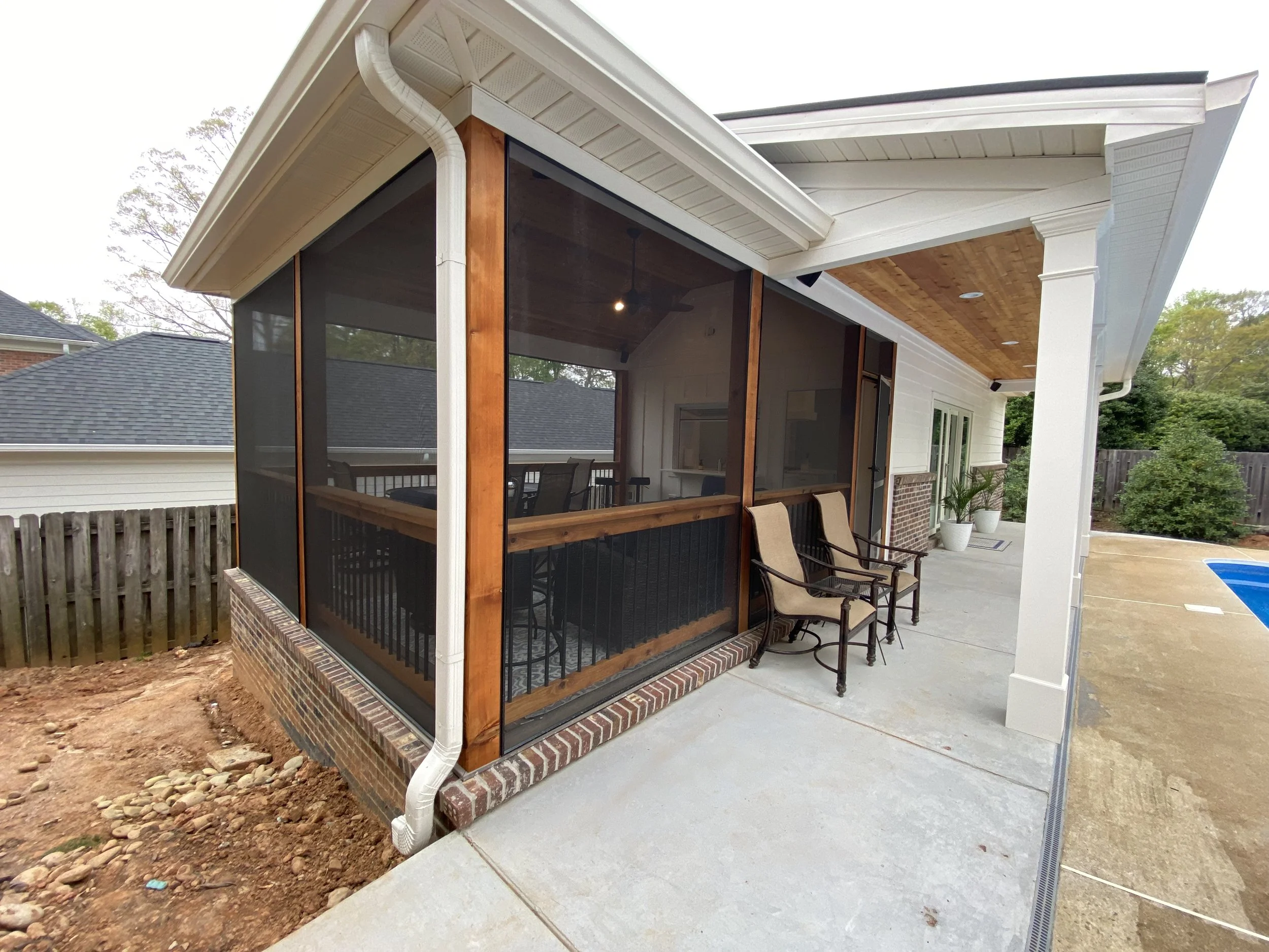 Exterior of detached pool house screened in porch and covered open front porch. Screen-Eze screen system. Fiber cement siding. Brick foundation.