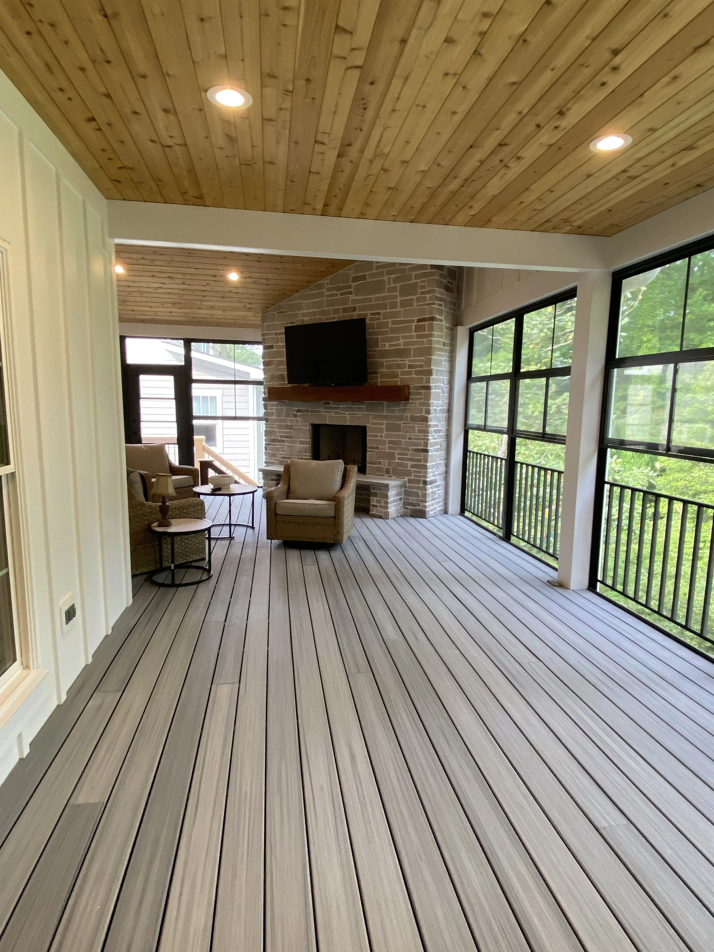 Large three season porch addition. Eze Breeze window system with aluminum safety rail outside window units. TimberTec composite decking. Cedar tongue and groove ceiling. Fiber cement board and baton siding. Stone fireplace.