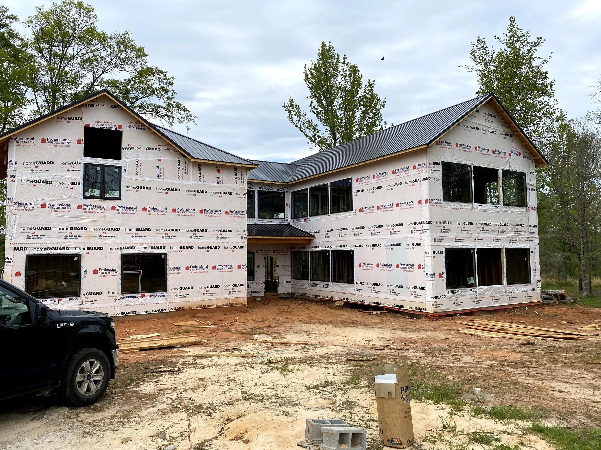 Framing complete. Black Tough Rib metal roofing. Vinyl Plygem windows.