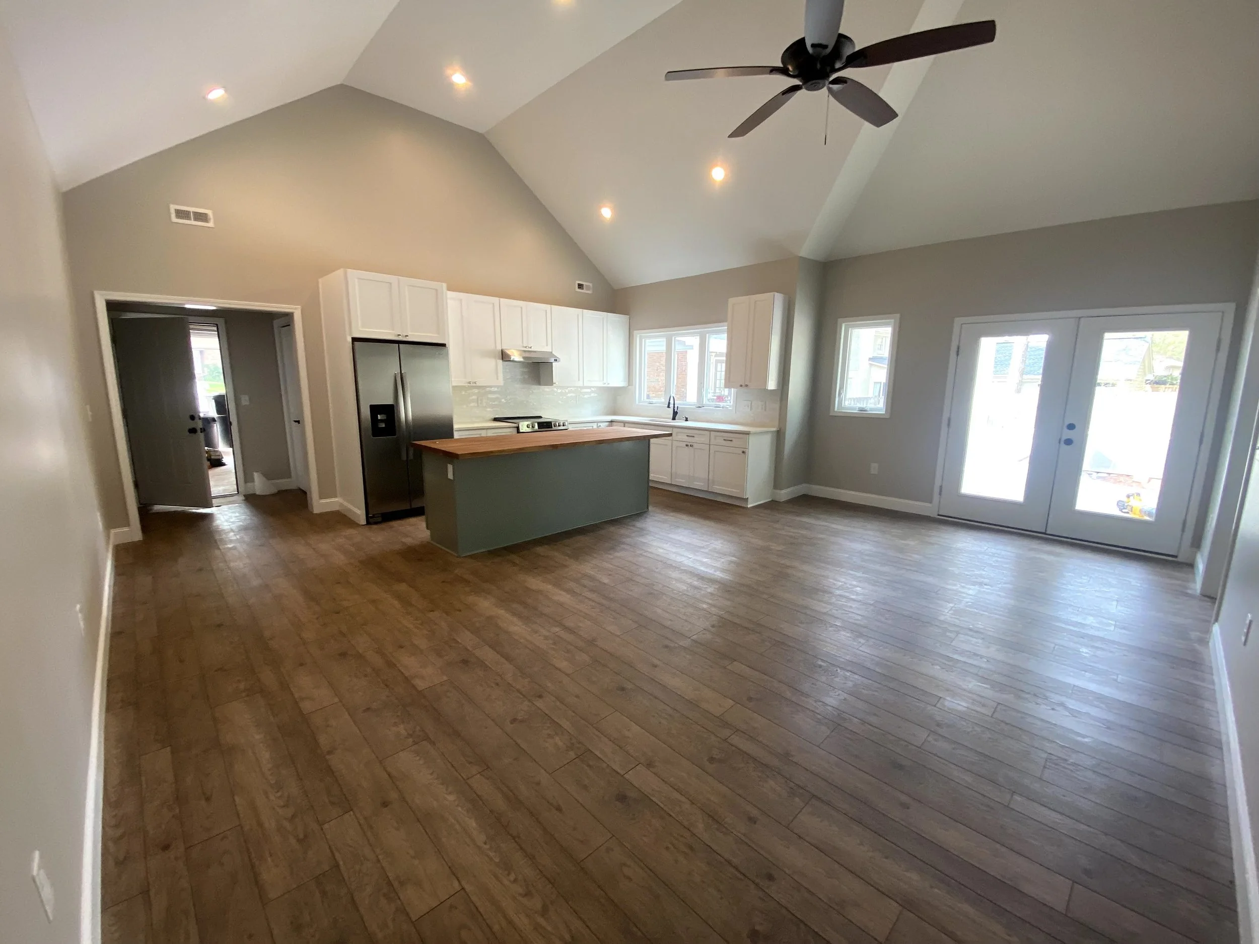 Interior of a pool house/mother in law suite built off the back of a detached garage. LVP flooring over slab foundation. Semi custom cabinets. Vaulted ceilings.