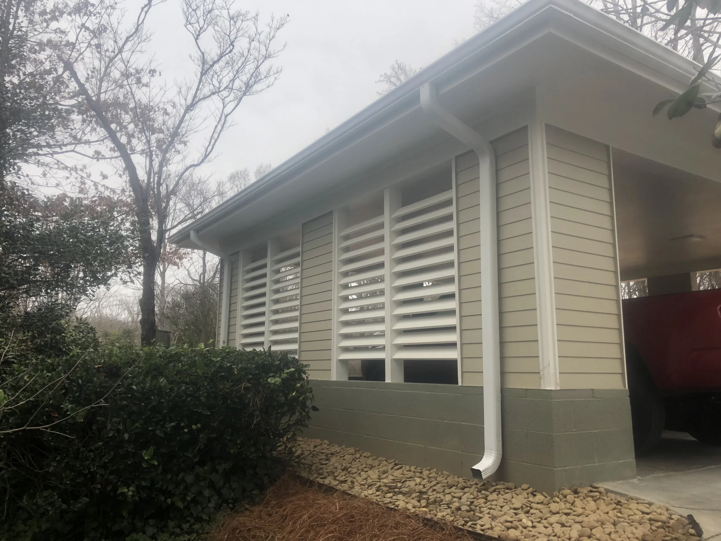 Detached carport with custom decorative privacy screening.