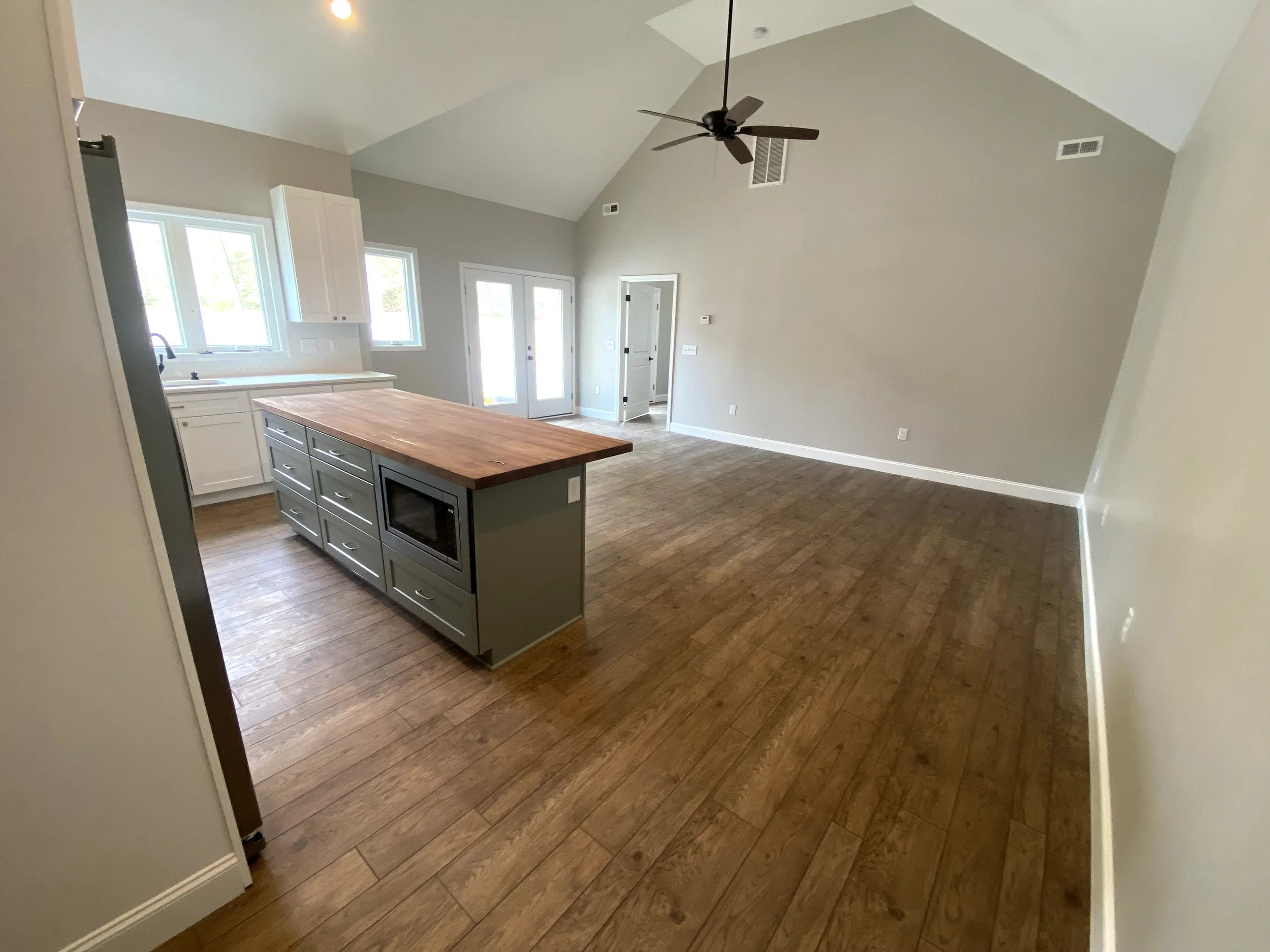 Interior of a pool house/mother in law suite built off the back of a detached garage. LVP flooring over slab foundation. Semi custom cabinets. Vaulted ceilings.