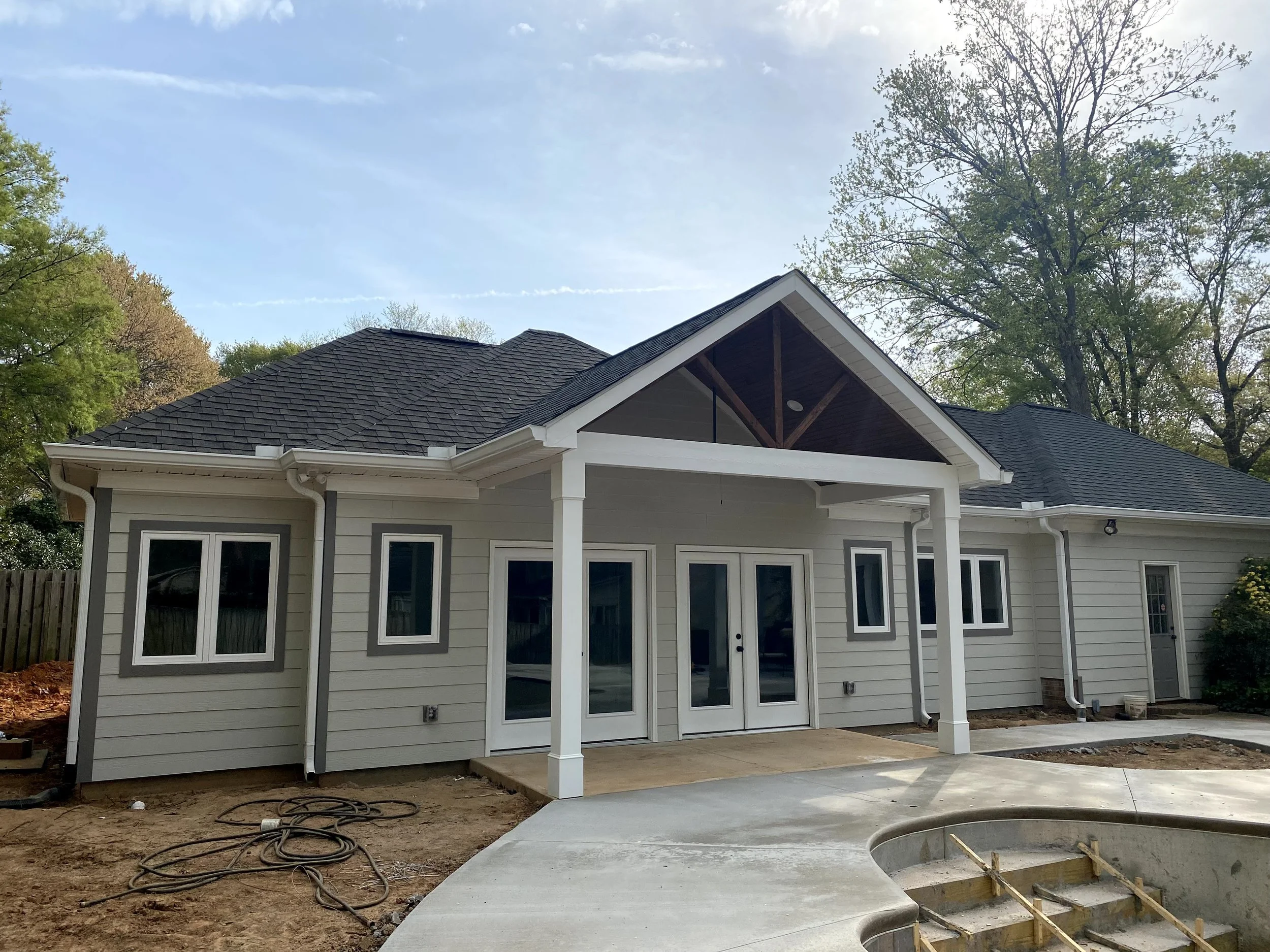 Exterior of pool house/mother-in-law suite built off of detached garage and beside a new pool. Fiber cement plank siding. Pine tongue and groove porch ceiling. Decorative PVC columns.