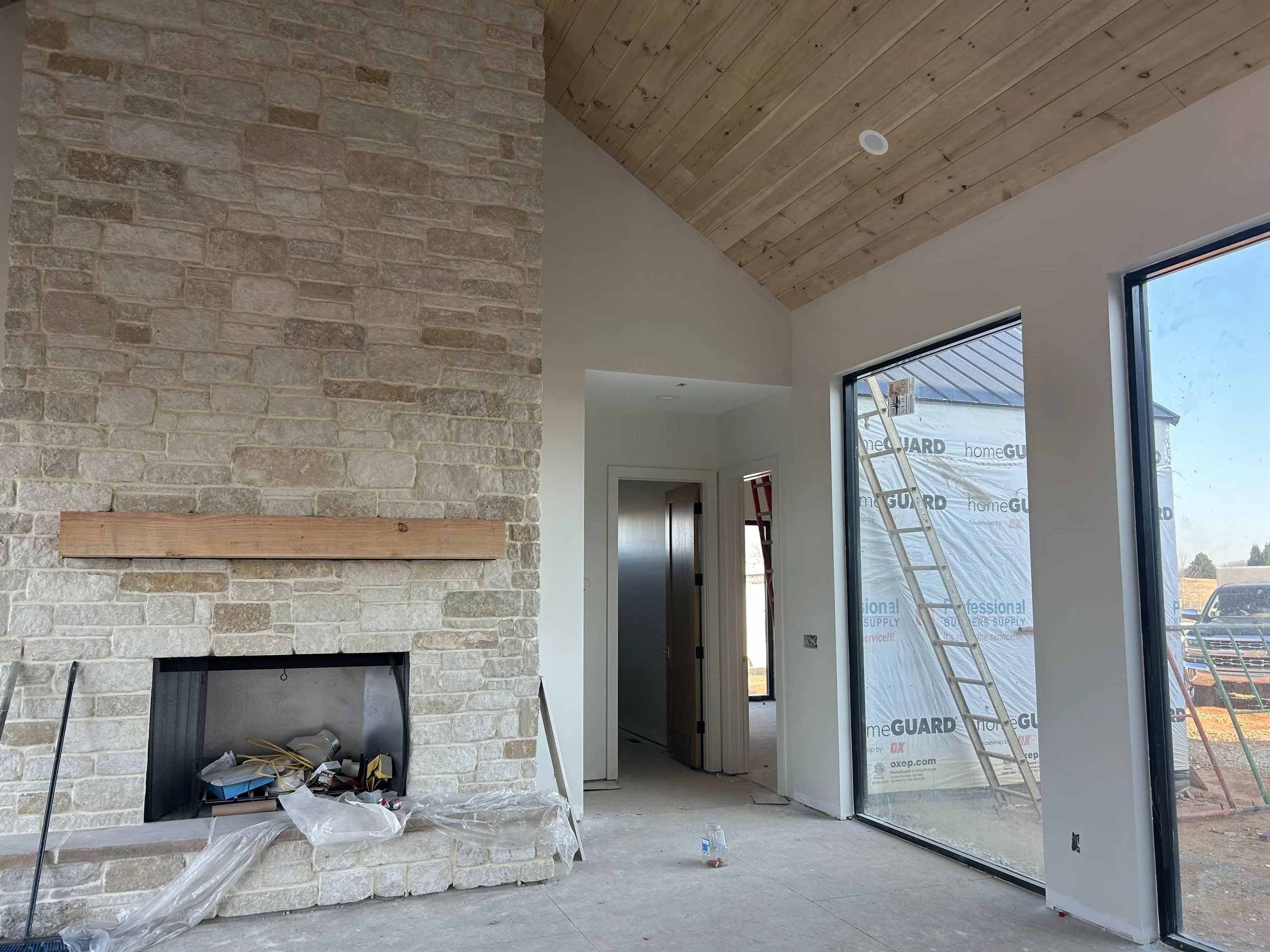 Real limestone veneer stone on fireplace. Rough sawn solid 8x8 douglas fir mantle. White pine tongue and groove ship lap on stained vaulted ceiling. Large aluminum and glass Quaker picture windows.