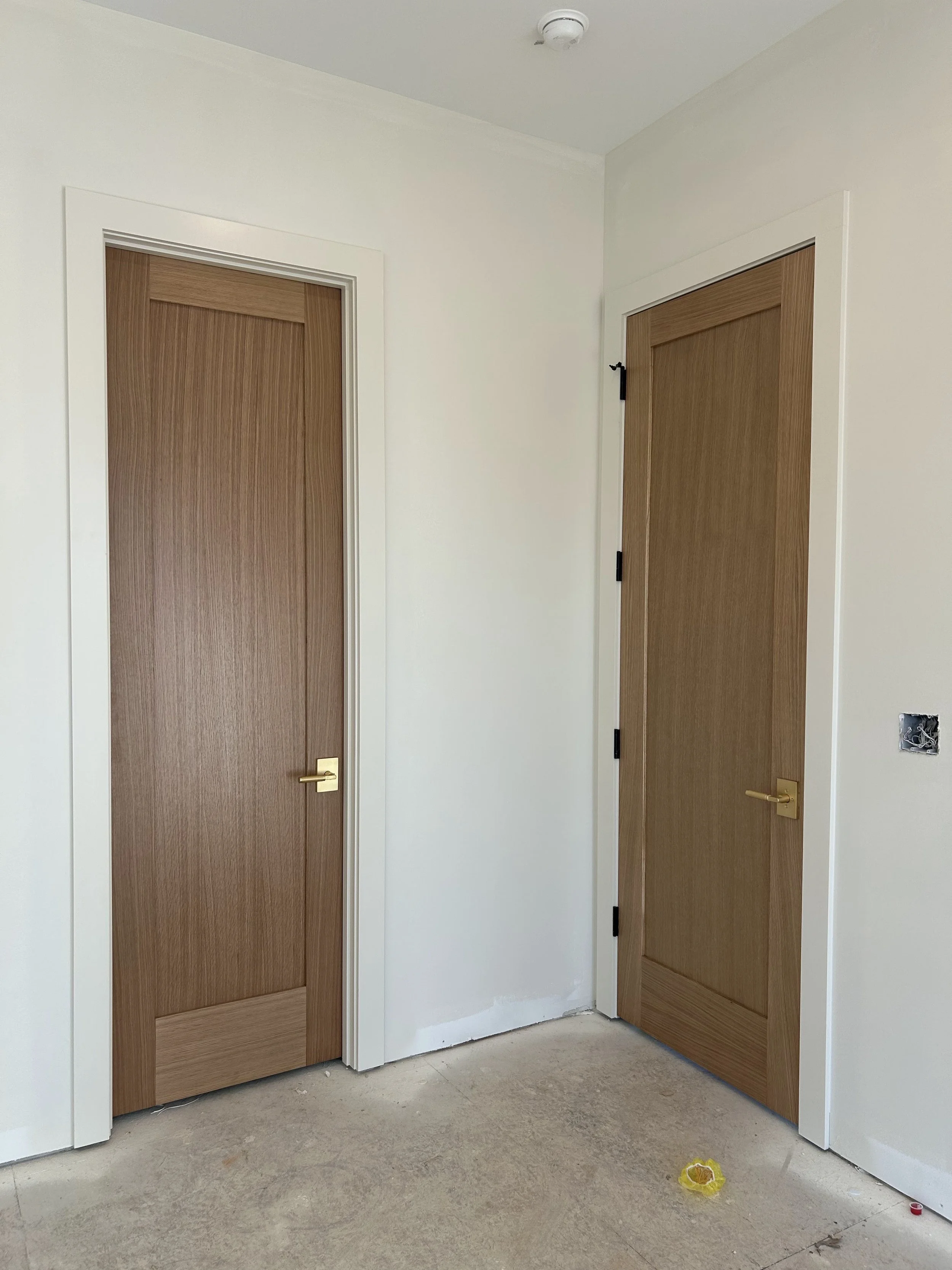 8' tall solid white oak interior doors with brushed gold lever handles.