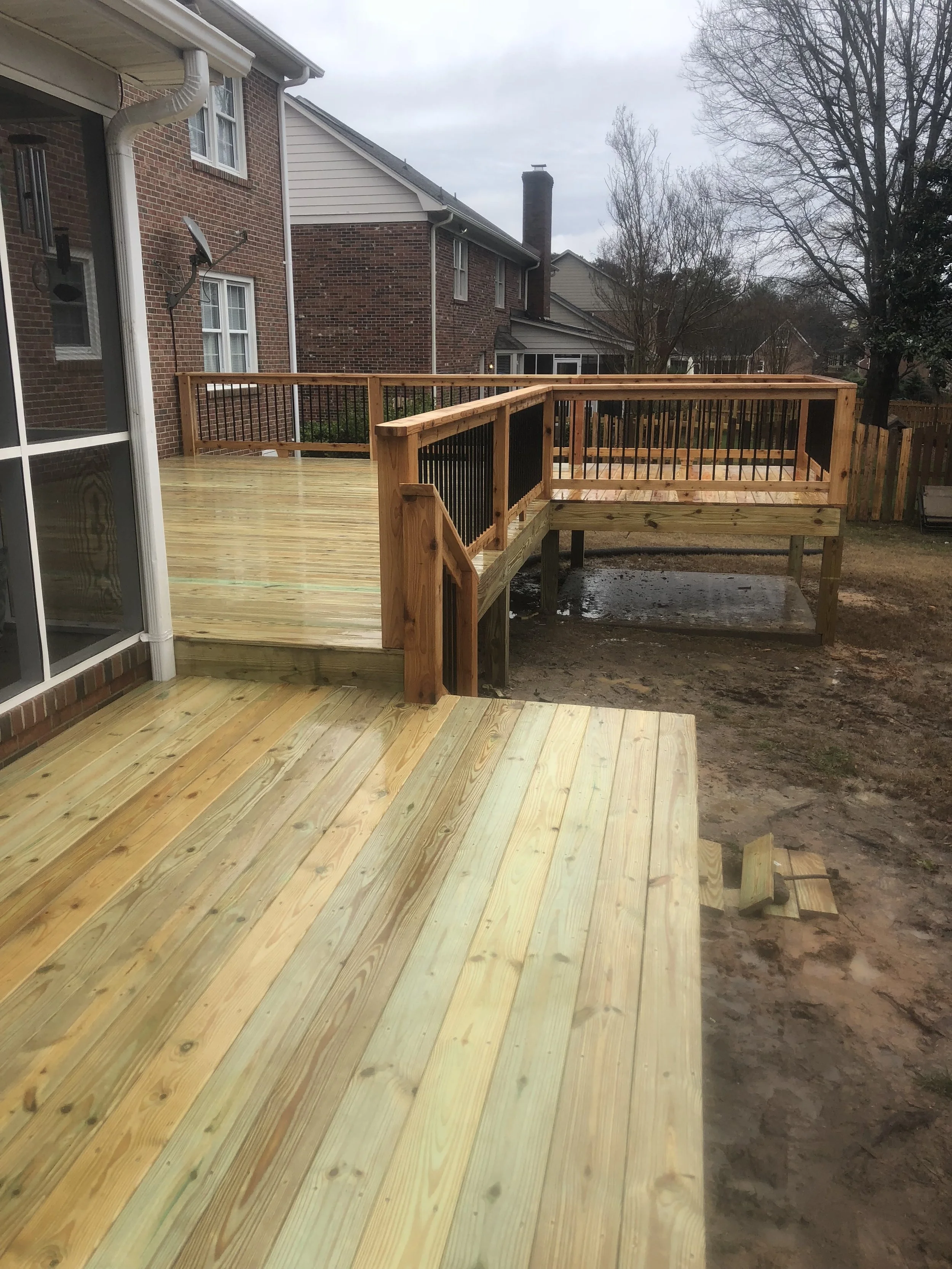 Pressure treated wood deck and cedar handrails with aluminum balusters.