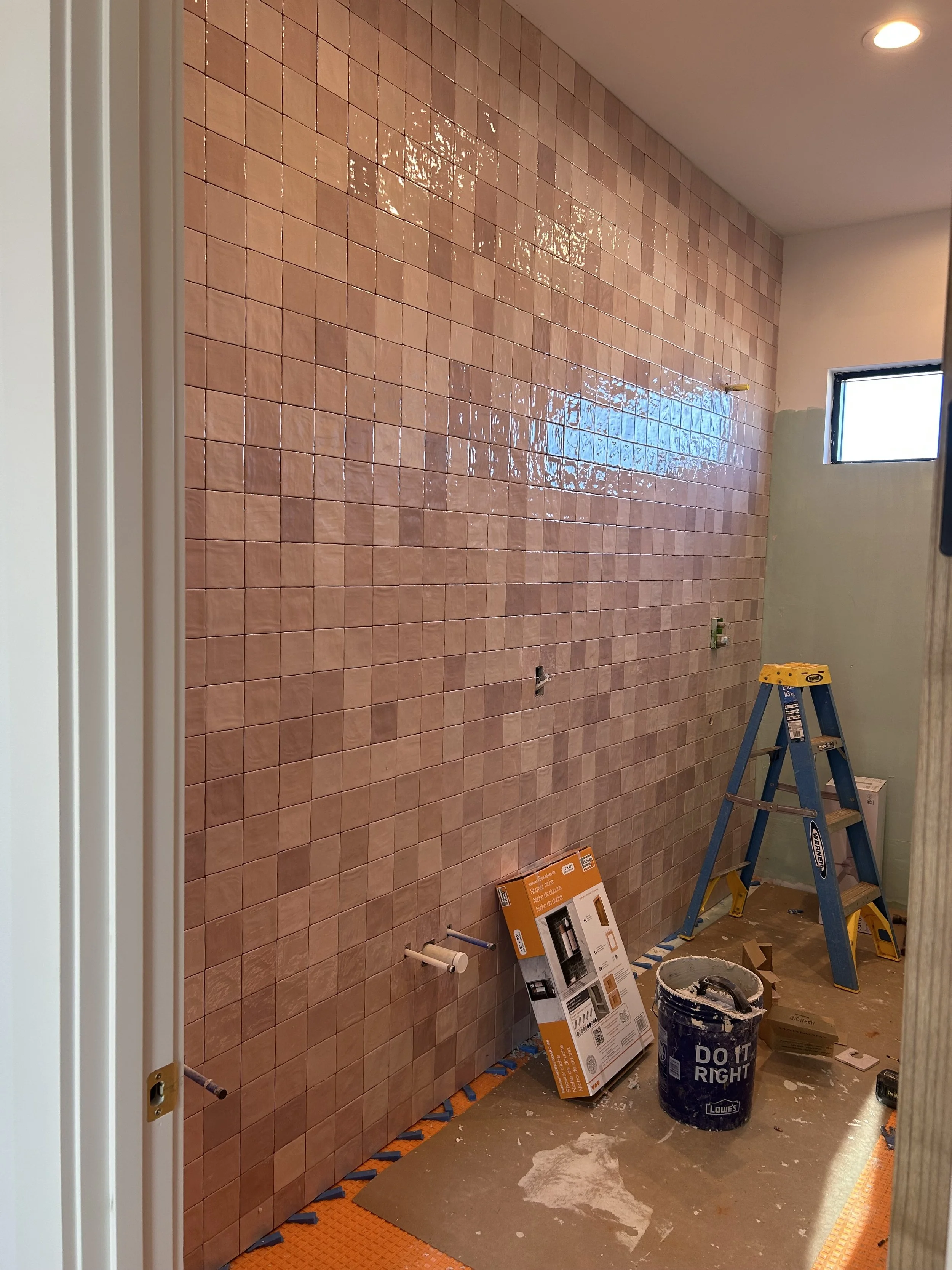 4x4 pink square tiles installed on bathroom wall to ceiling.