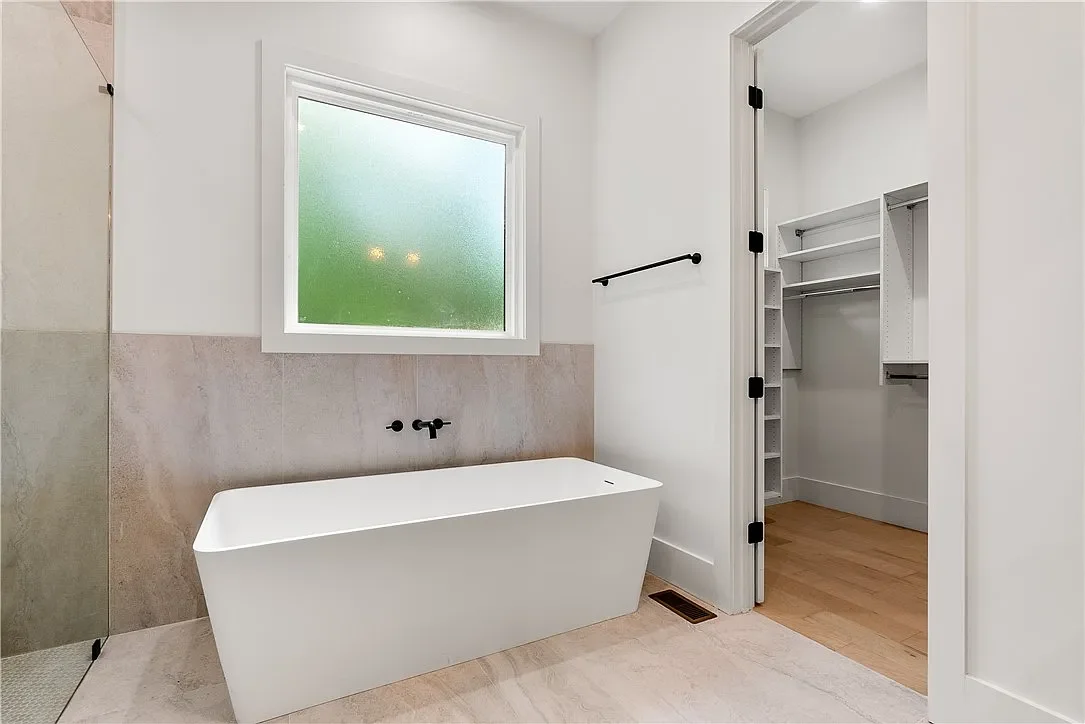 Large freestanding resin bath tub with wall mount bath tub faucet.