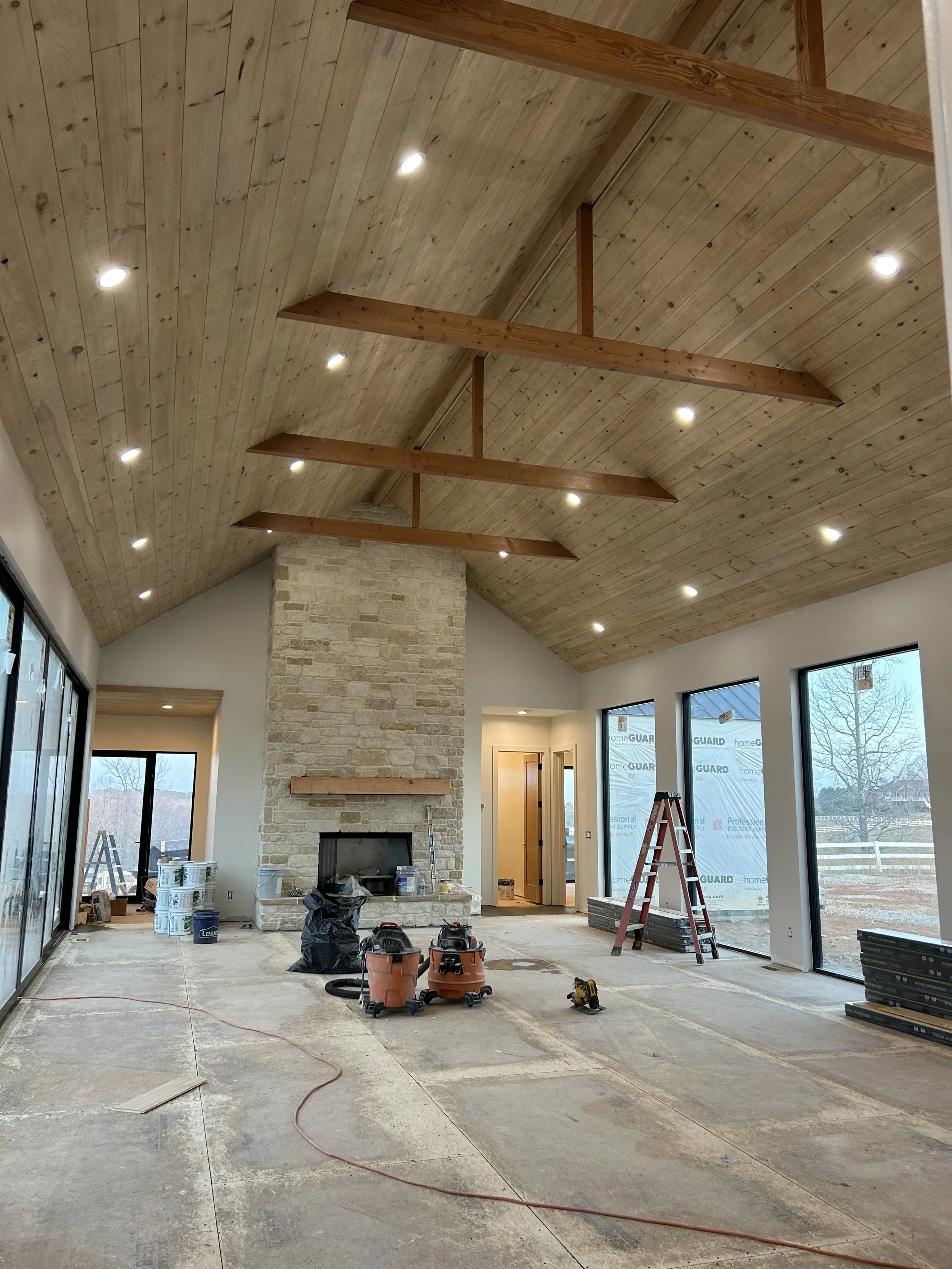 Real limestone veneer stone on fireplace. Rough sawn solid 8x8 douglas fir mantle. White pine tongue and groove ship lap on stained vaulted ceiling. Large aluminum and glass Quaker picture windows. Douglas fir 4x8 structural collar ties with 4x4 king