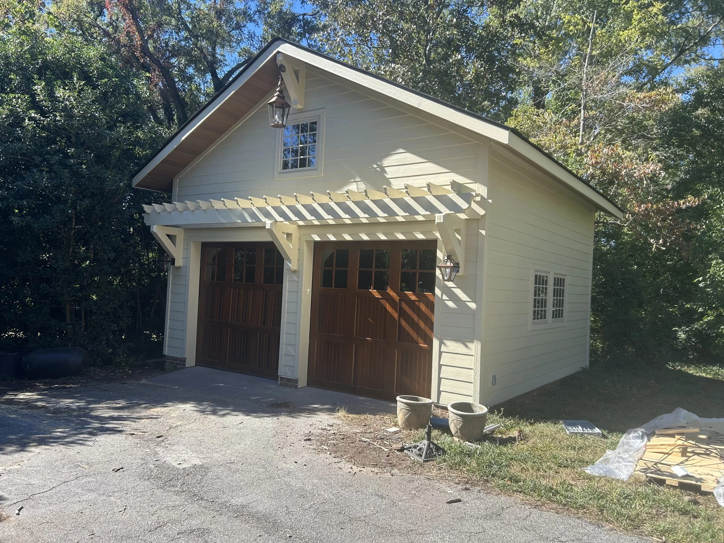 Detached two car garage with large attic storage above. Fiber cement siding with custom trellis above custom solid wood garage doors. Vinyl casement windows.