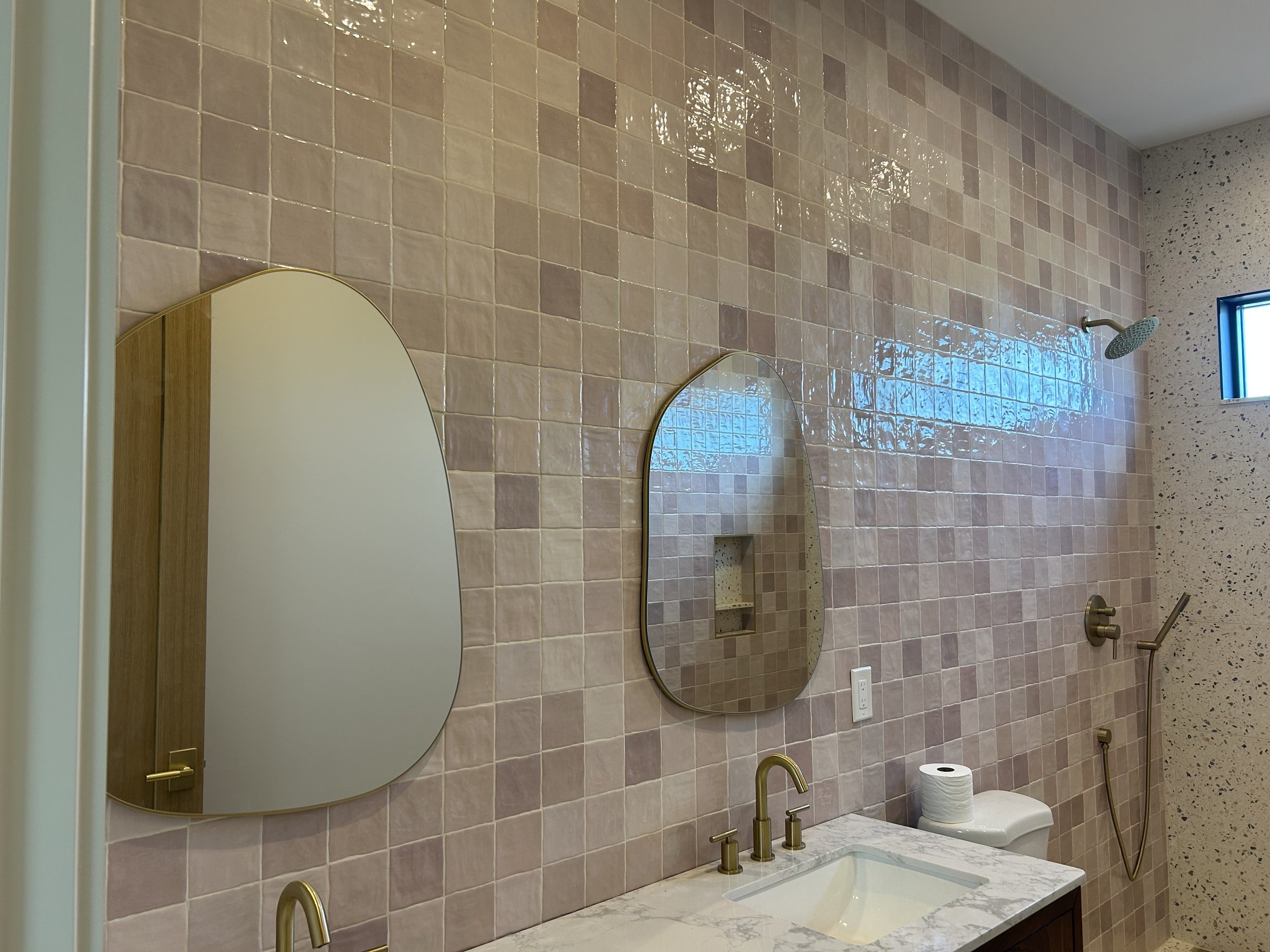 Finished bathroom tile with decorative mirrors.