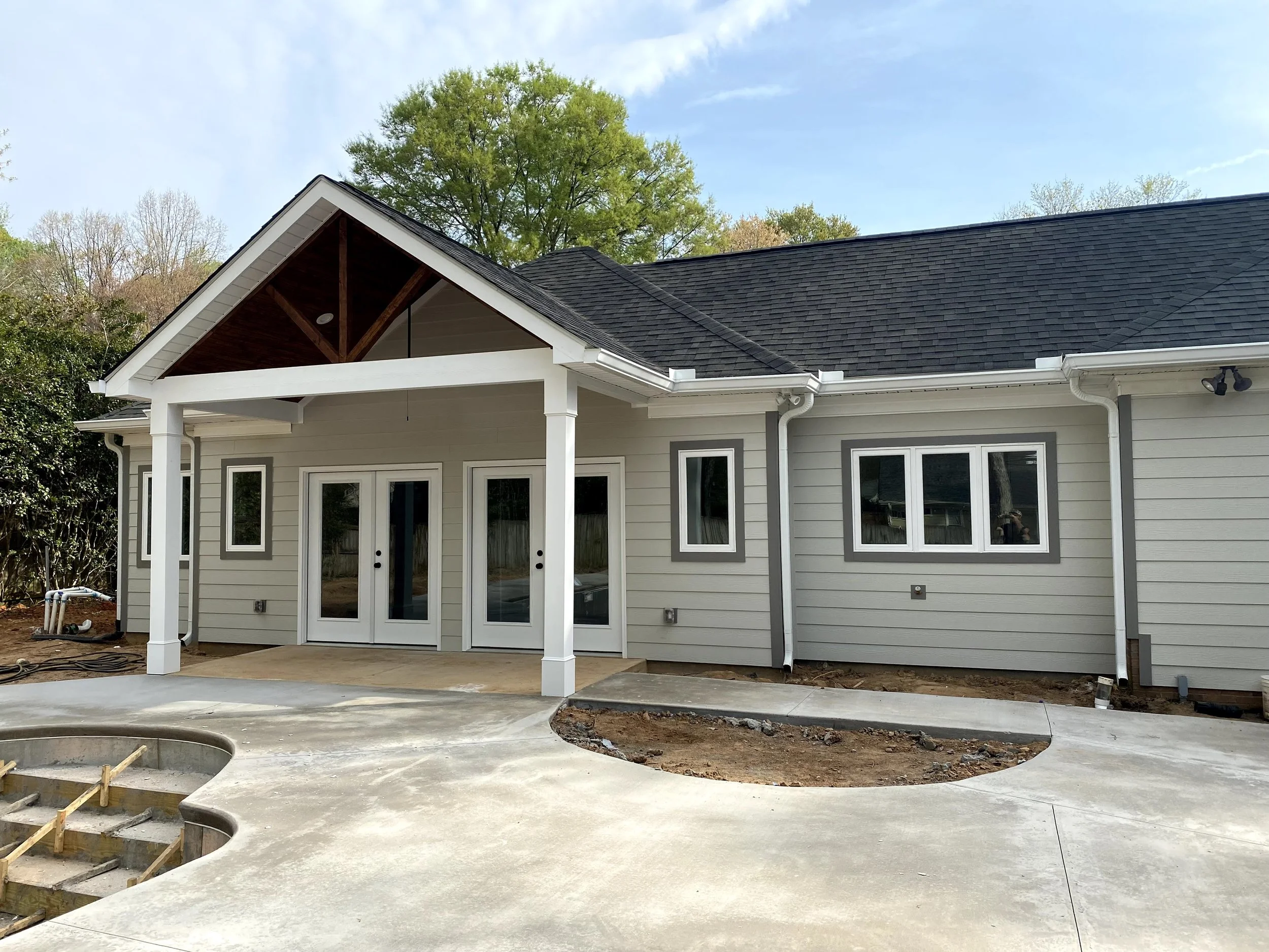 Exterior of pool house/mother-in-law suite built off of detached garage and beside a new pool. Fiber cement plank siding. Pine tongue and groove porch ceiling. Decorative PVC columns.