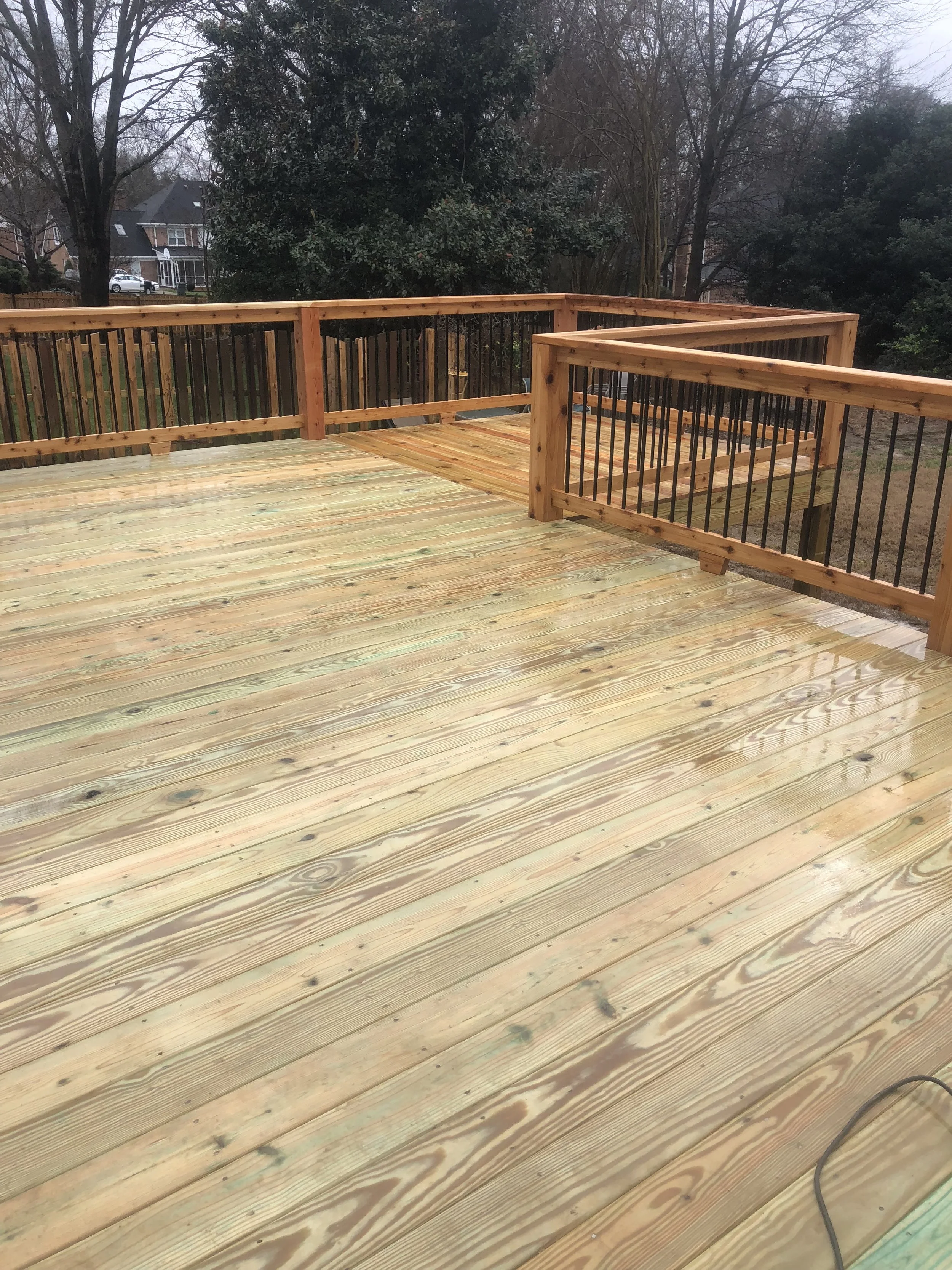 Pressure treated wood deck and cedar handrails with aluminum balusters.