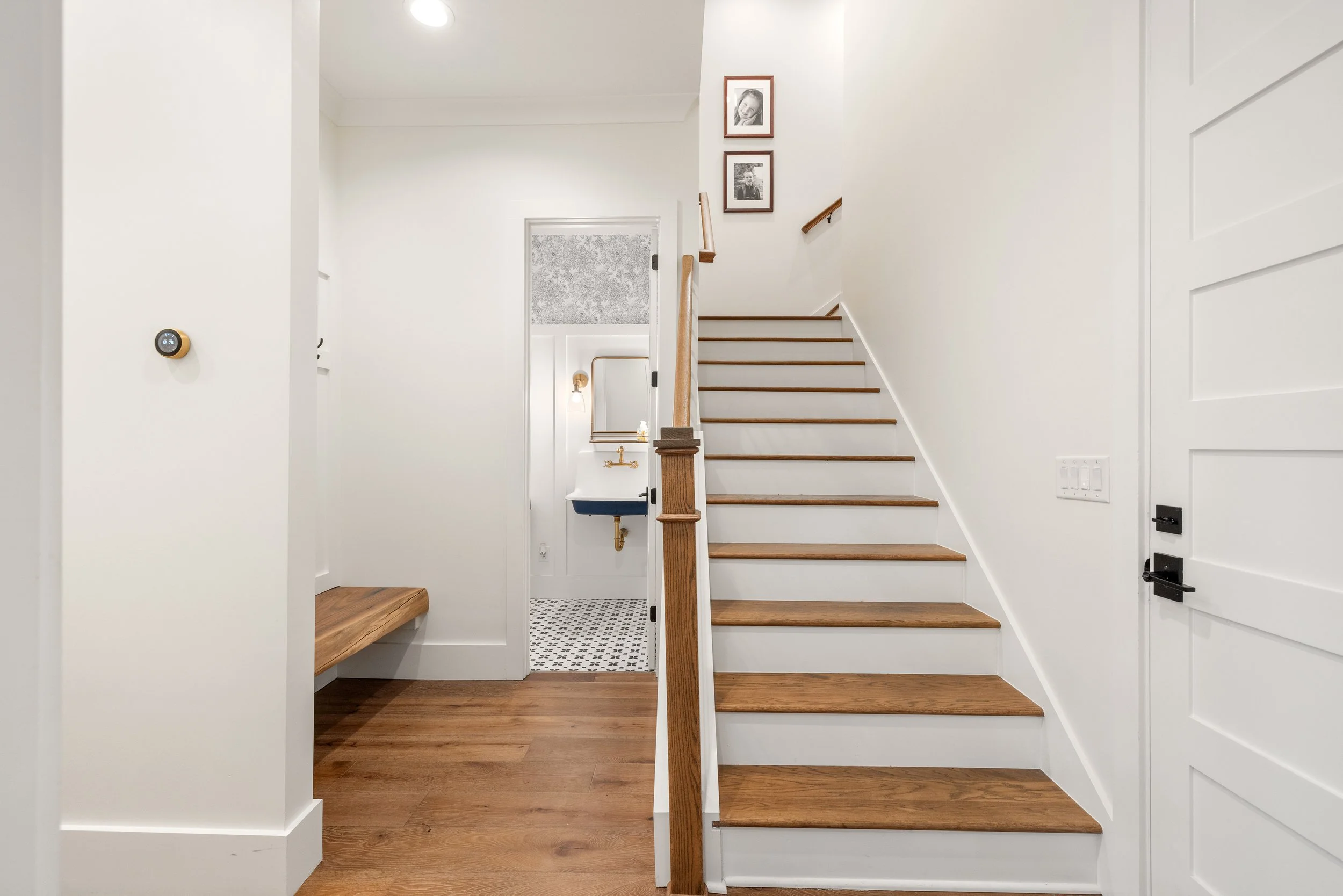 Stairs to bonus room suite above garage. Solid oak treads with paint grade risers. Half bath with wall mount sink. Custom 5"x16" wood bench with live edge.