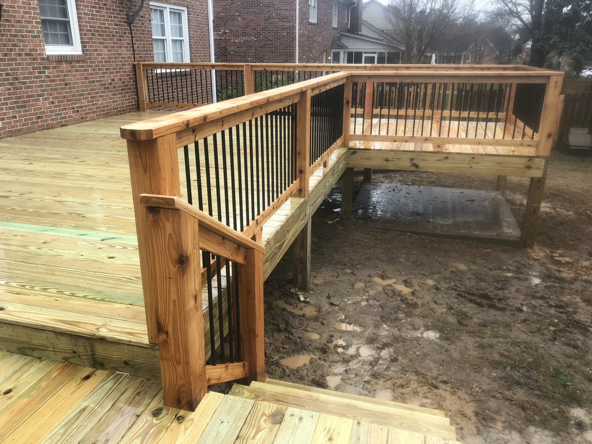 Pressure treated wood deck and cedar handrails with aluminum balusters.