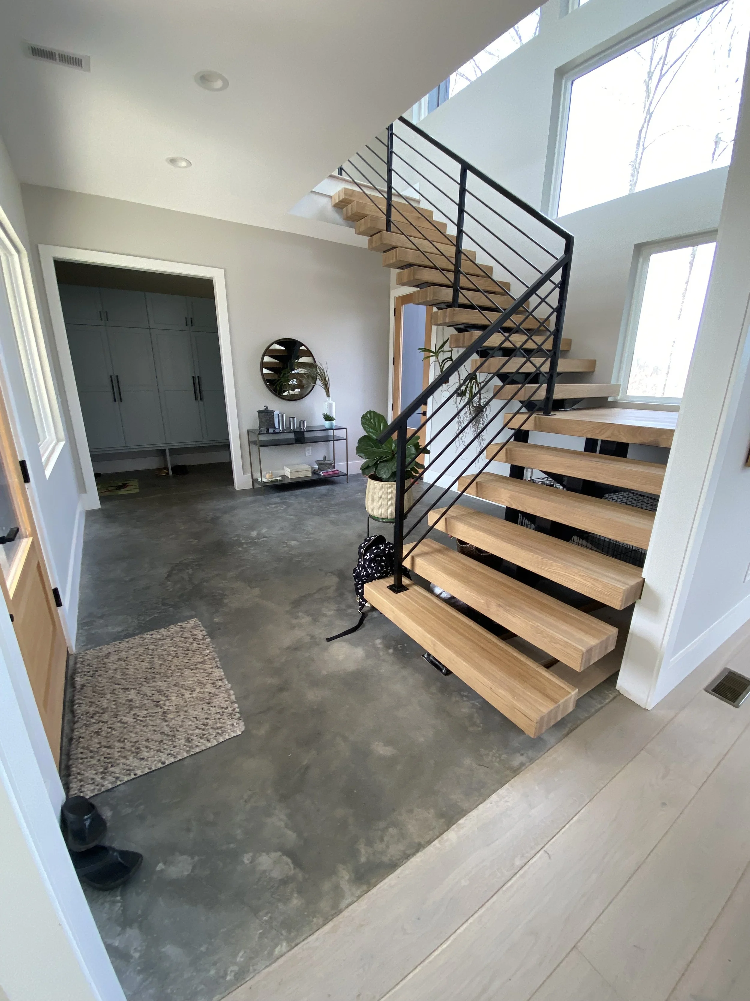 Custom welded steel beam stairs. 4"x12" solid oak treads and solid oak landing. Custom welded metal handrail.