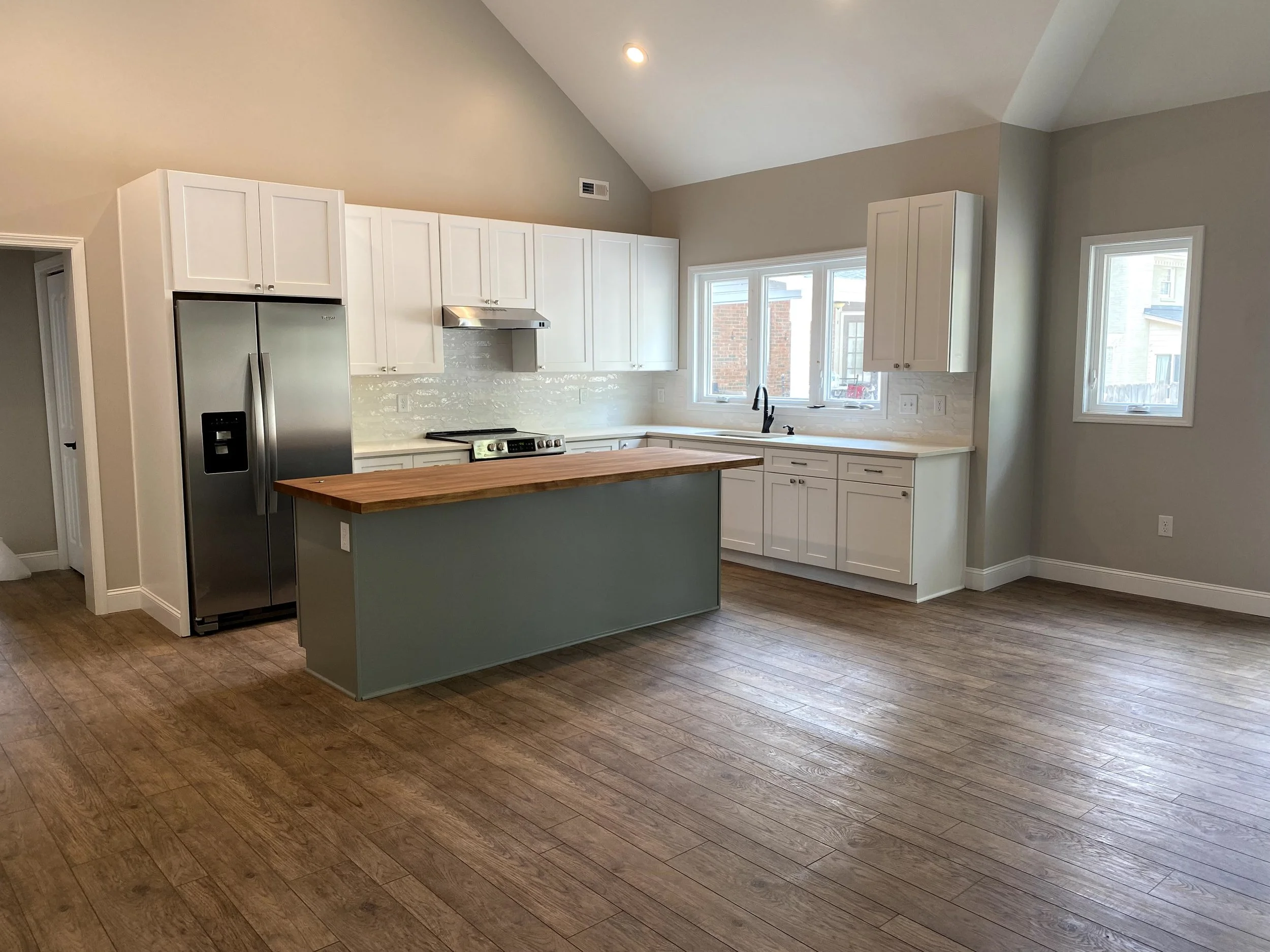 Interior of a pool house/mother in law suite built off the back of a detached garage. LVP flooring over slab foundation. Semi custom cabinets. Vaulted ceilings.