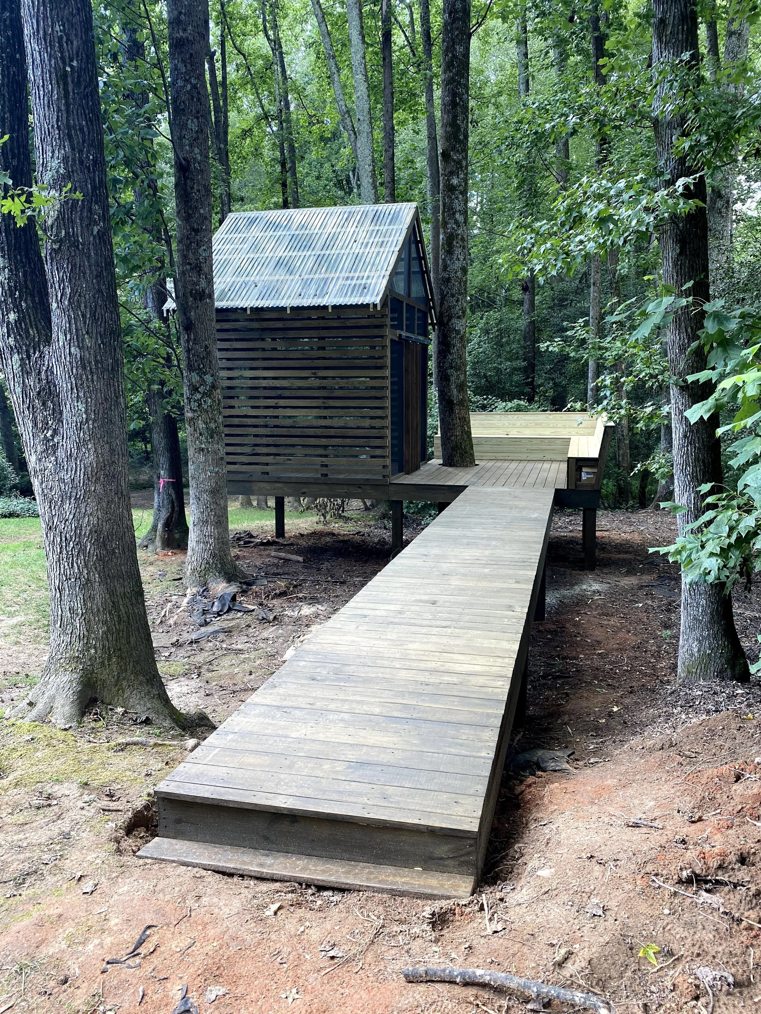 Custom tree house with open wood deck and angled back benches.