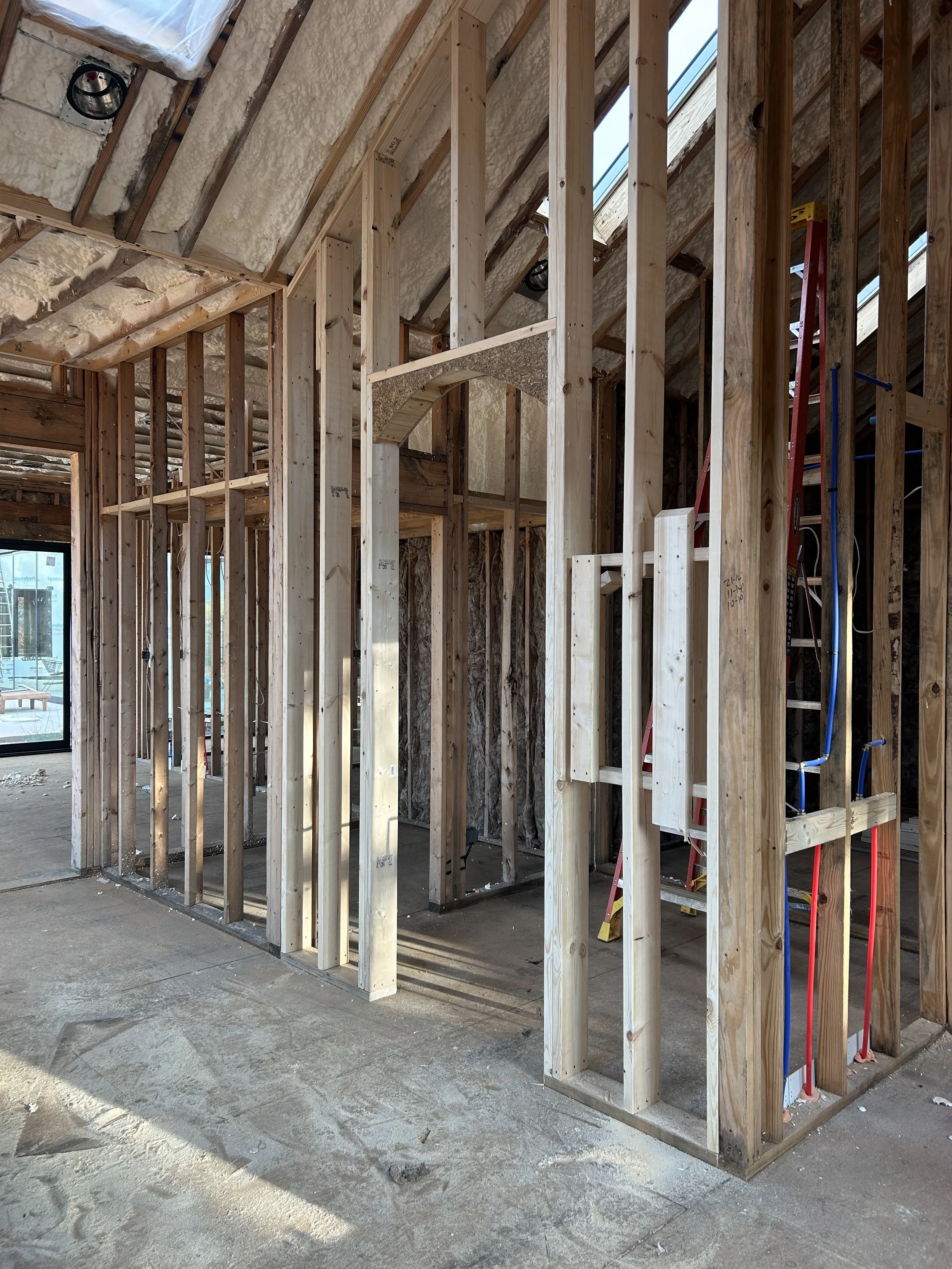 Interior framing of walk in primary shower. Hidden sauna room accessed from shower. Spray foam insulation in roof deck. Batt insulation in walls. 