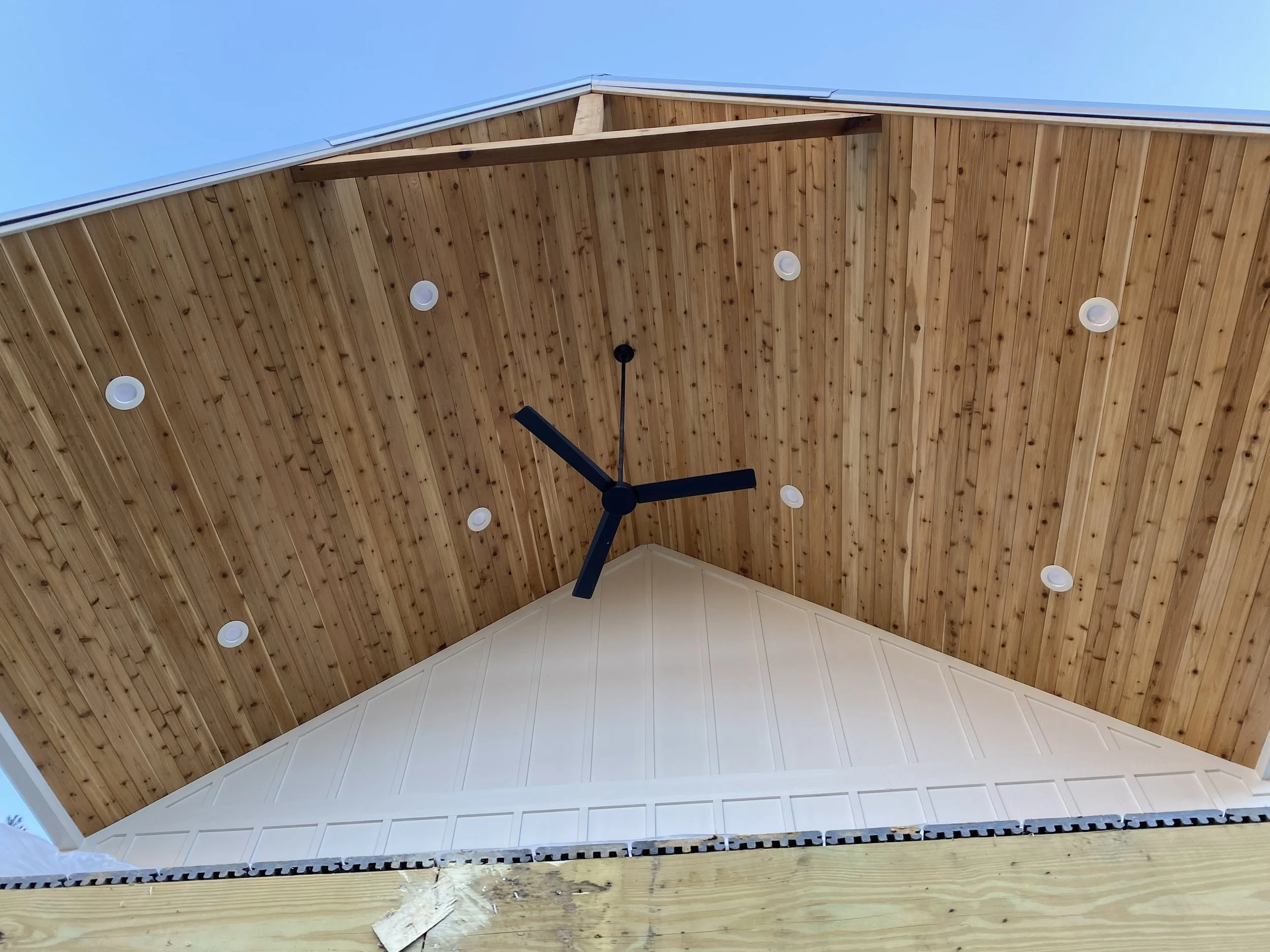 1x6 cedar tongue and groove board installed on front porch ceiling. Structural 4x6 cedar collar tie with king post. LED recessed can lights and ceiling fan. Fiber cement board and baton siding.