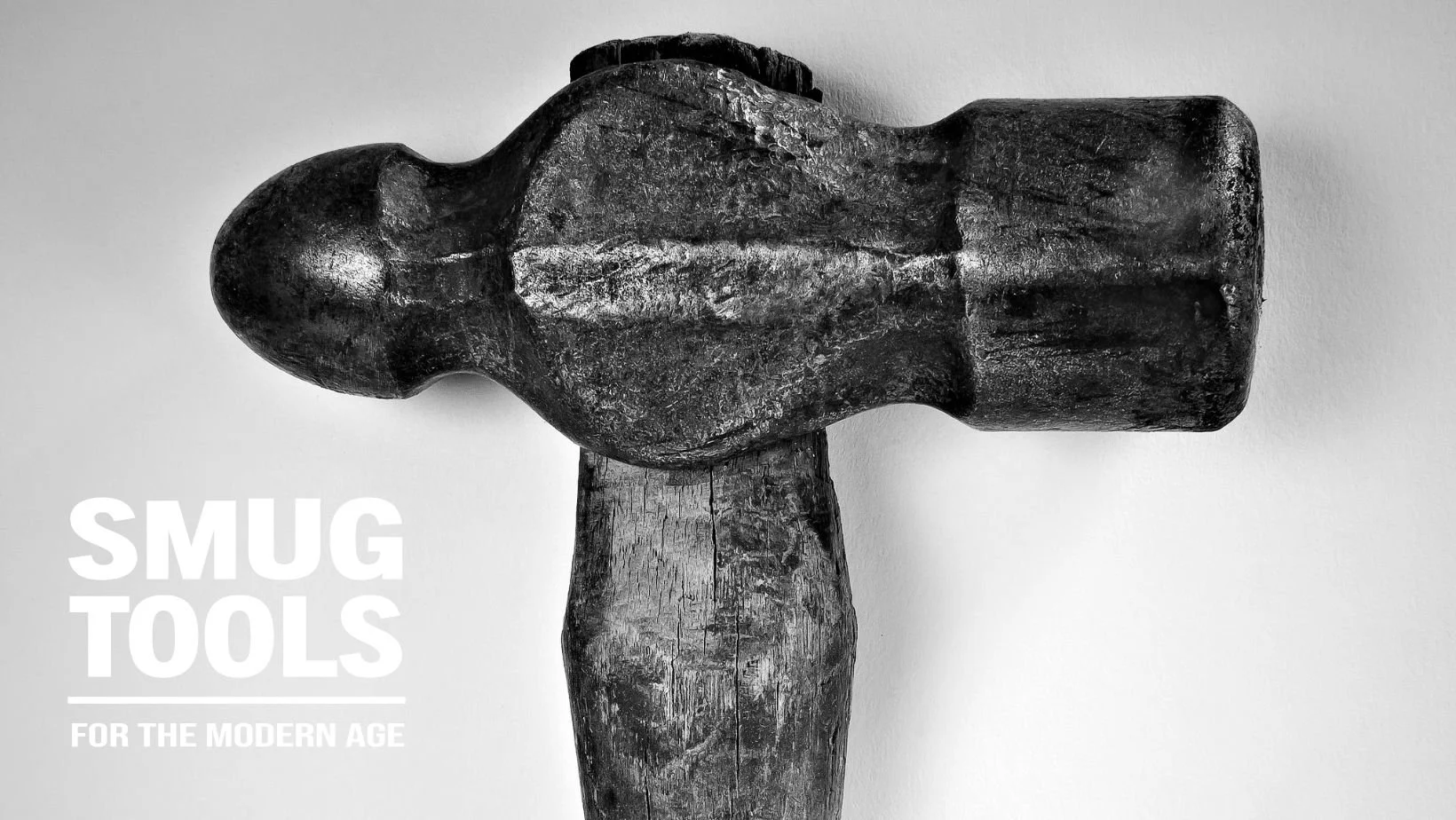 SMUG TOOLS "For the Modern Age" banner with a black-and-white close-up of a weathered ball peen hammer head and cracked wood handle