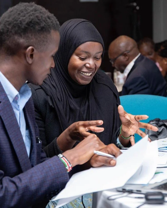 Two participants working through documents at a workshop