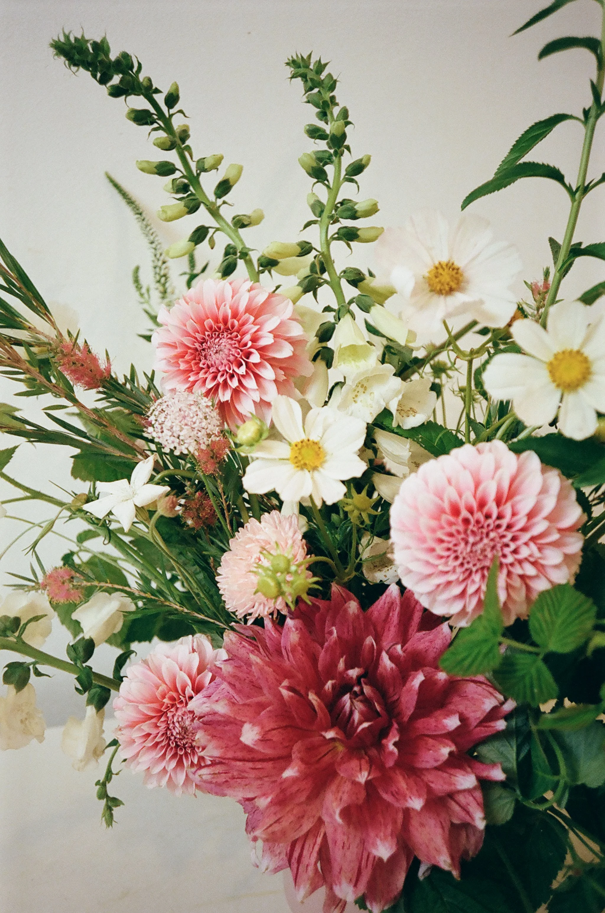 A bouquet of pink, white, and purple flowers with green leaves and stems.