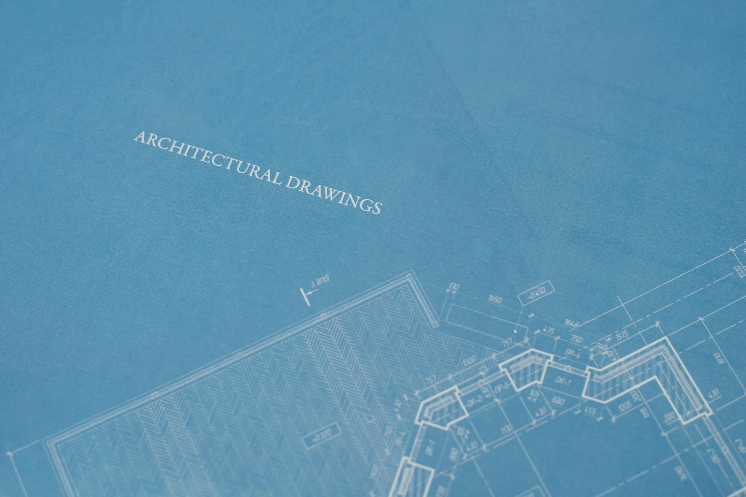 Blue blueprint of architectural drawings with technical details and measurements.