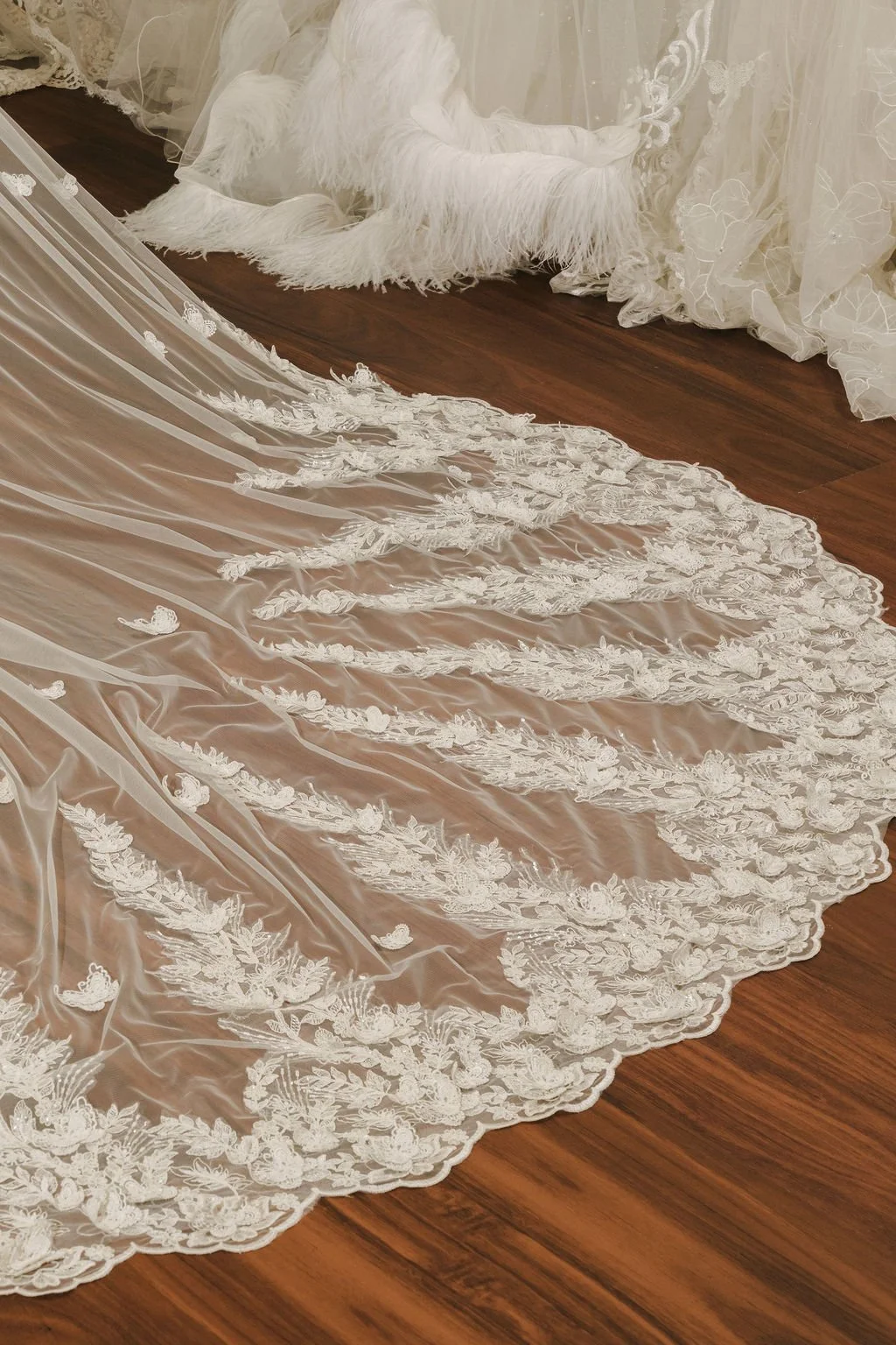 A wedding dress with lace and embroidery details on a floor.