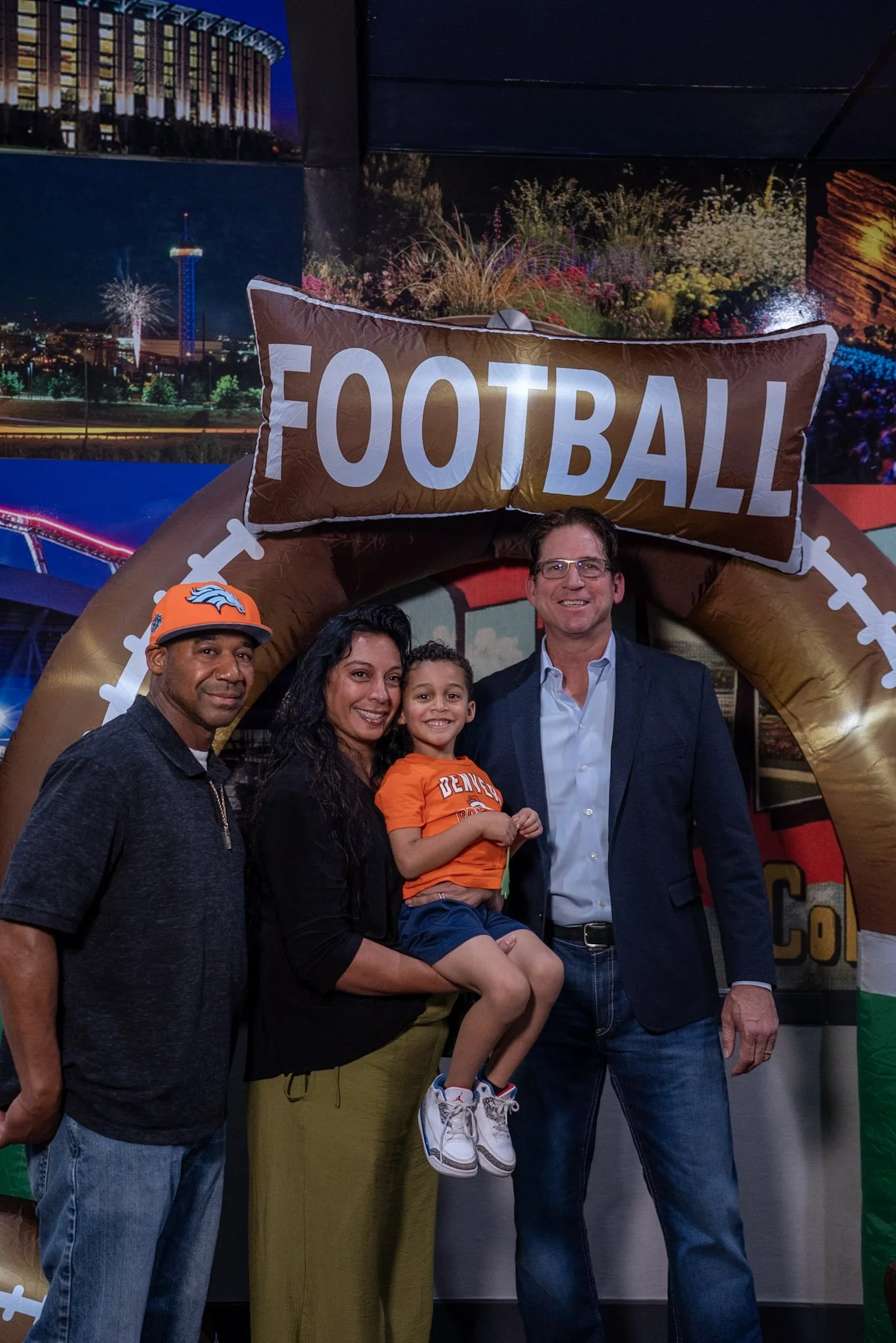 Denver legend Ed McCaffrey takes a photo with a family at the Denver Football Playbook meet and greet.