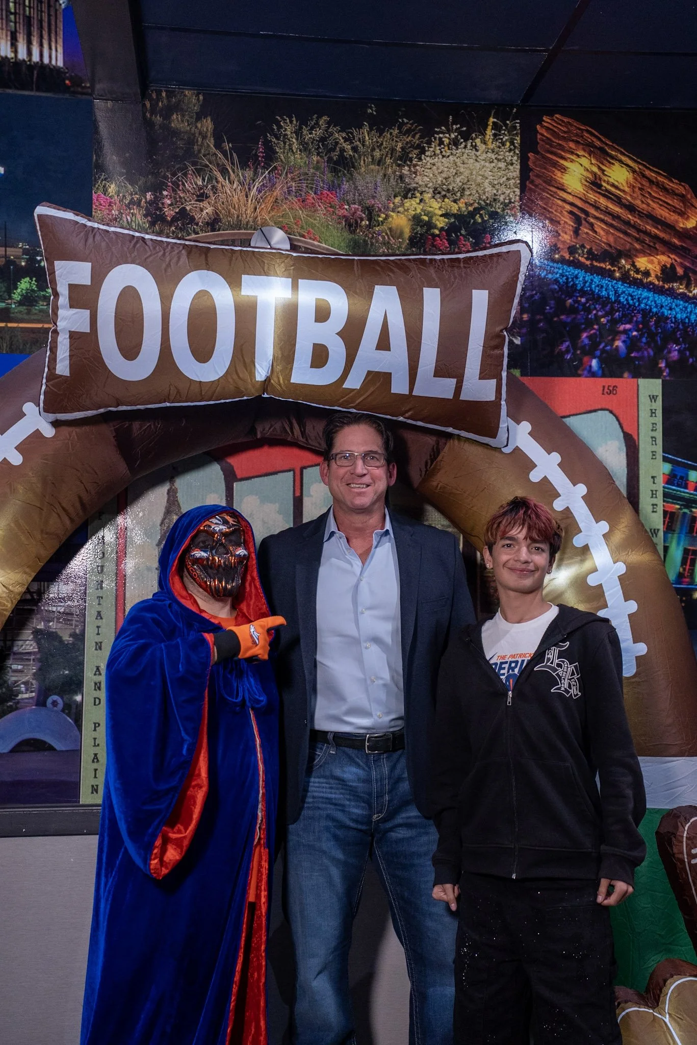 Ed McCaffrey takes a photo with two Denver Football Playbook guests after the live show.