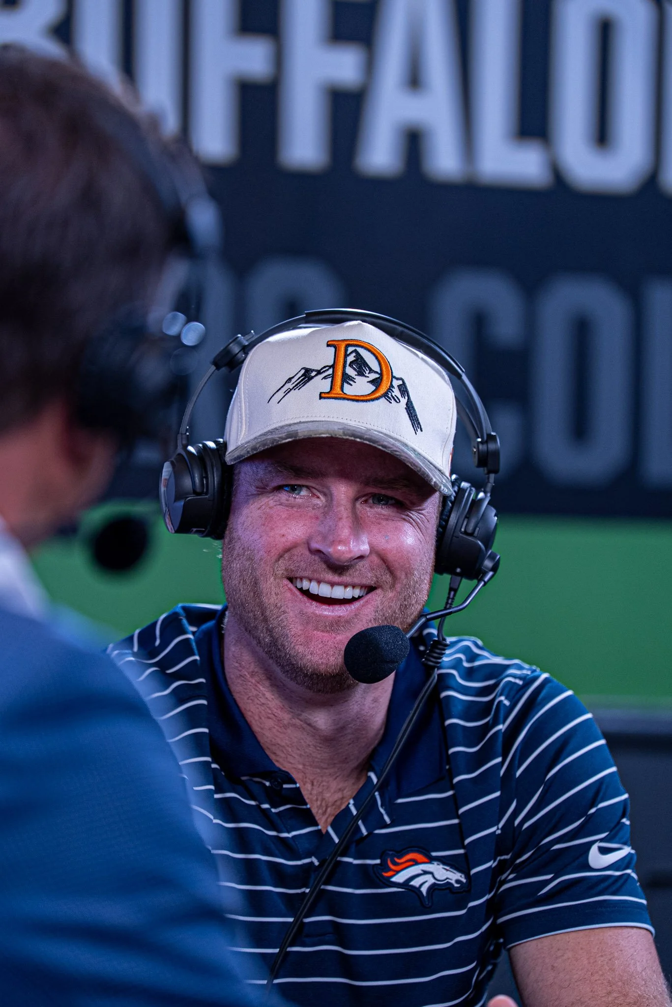 Wil Lutz smiling on stage during the first Denver Football Playbook live show in Westminster, Colorado