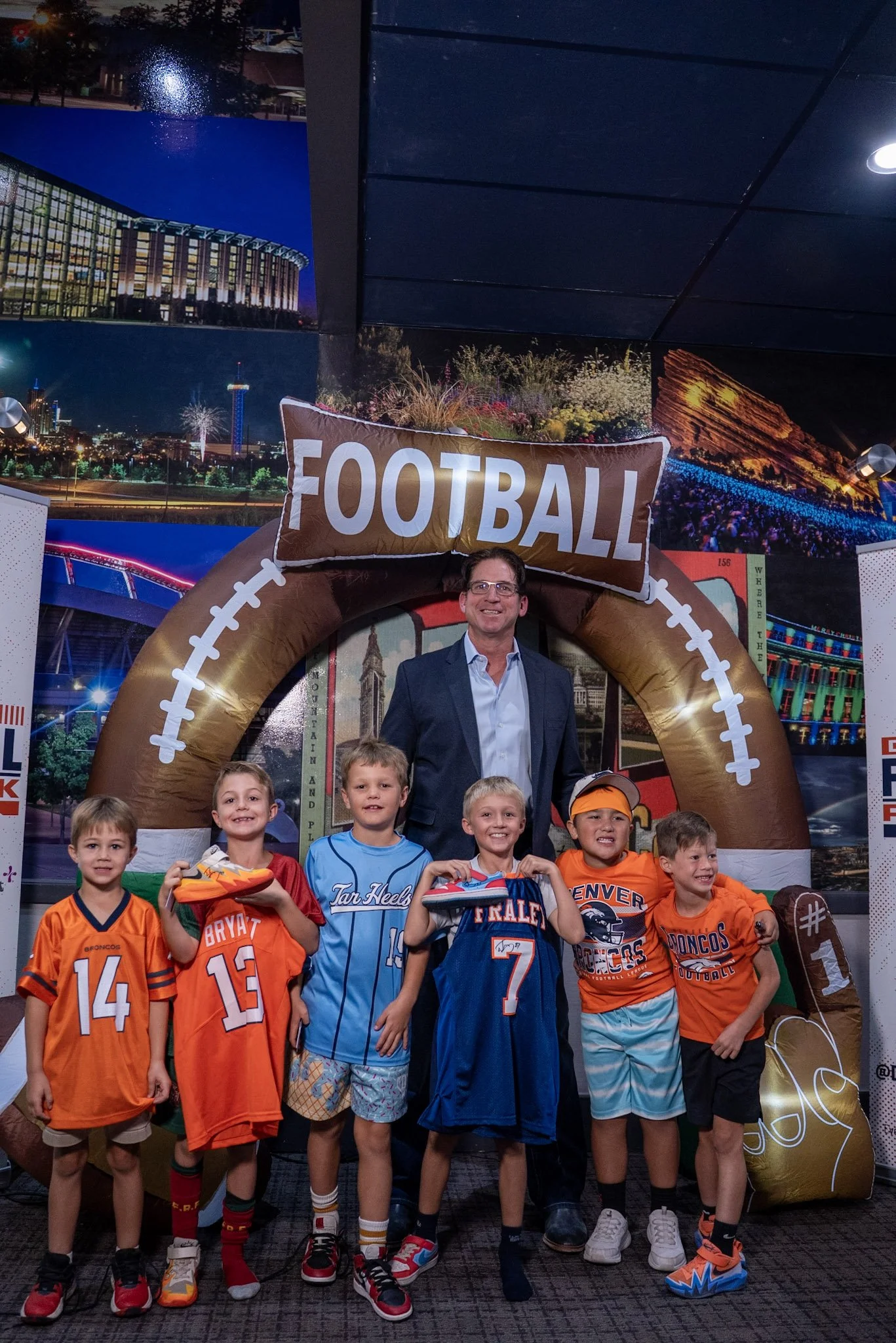 Ed McCaffrey poses with a group of kids at the Denver Football Playbook meet and greet.
