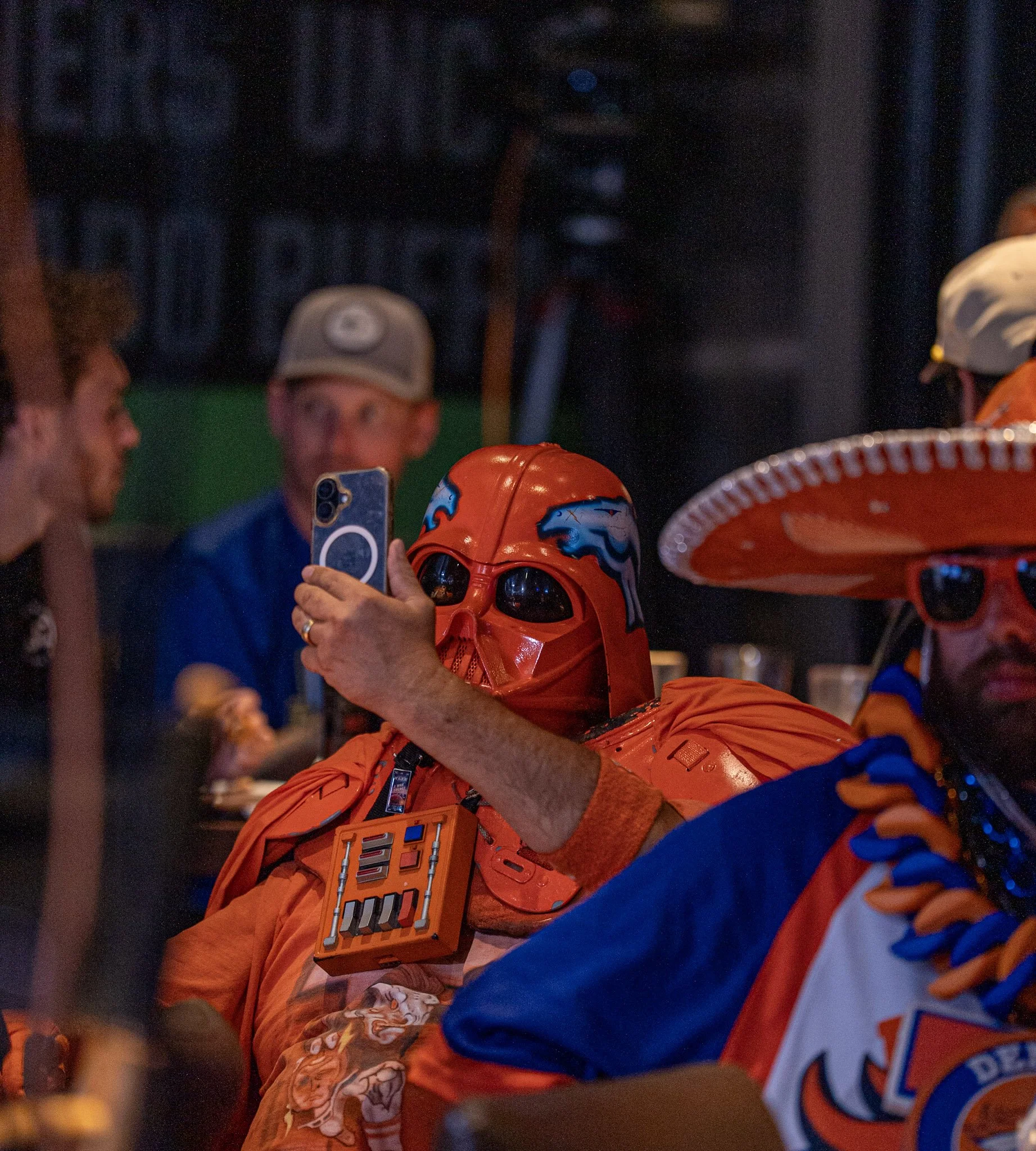 Fan taking a picture in the crowd at the first Denver Football Playbook live show at Dave & Buster's in Westminster