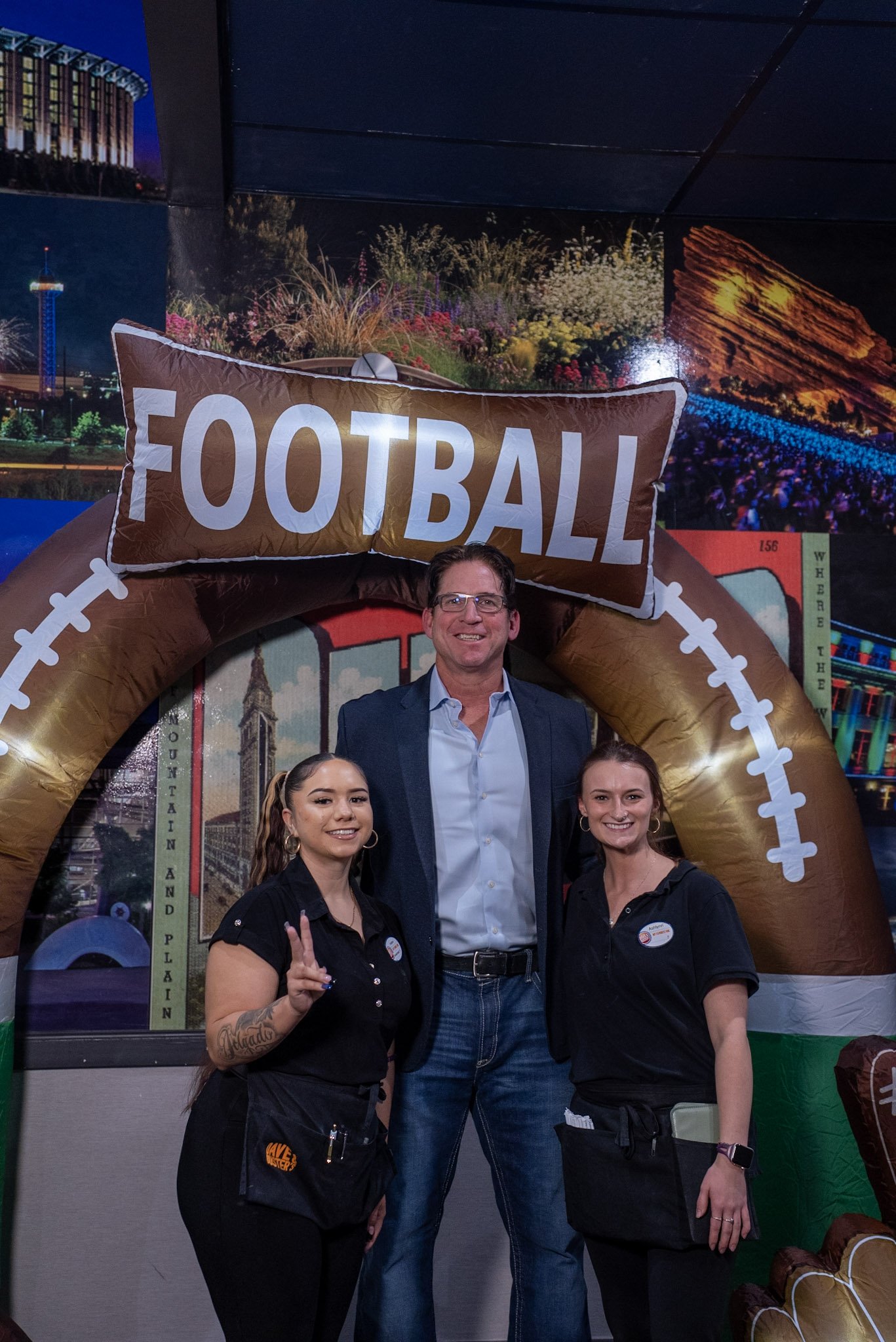 Denver legend Ed McCaffrey takes a photo with two guests at the Denver Football Playbook meet and greet.