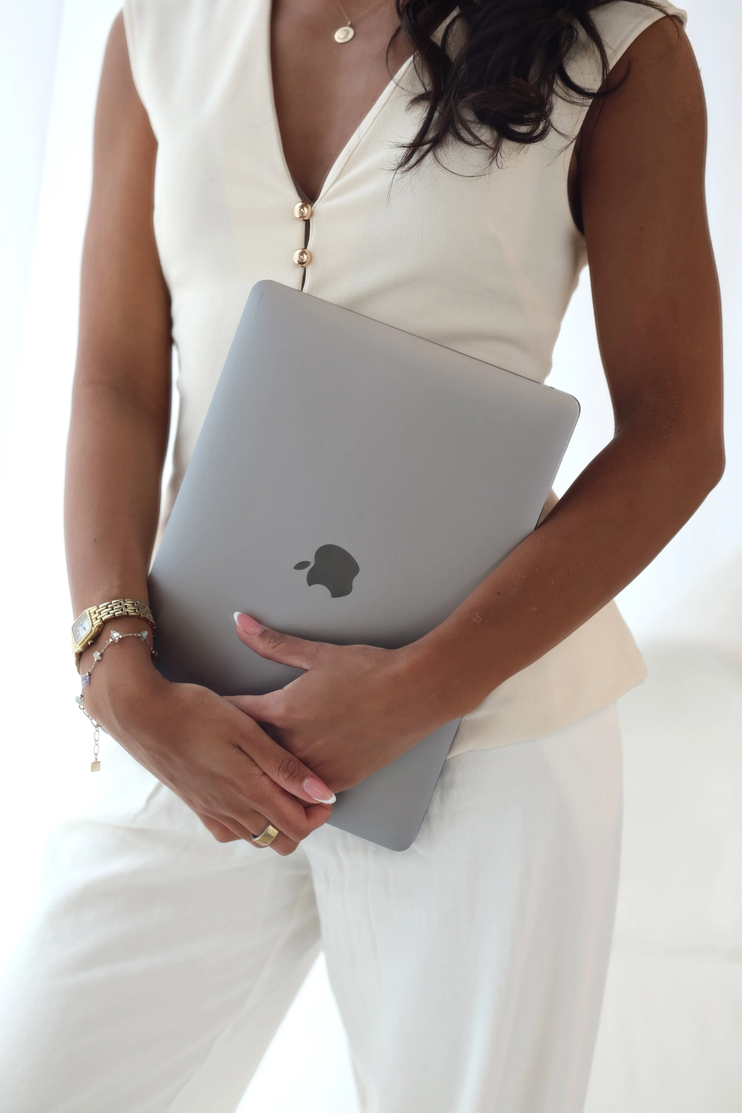 Summer standing beside a white sofa with an open laptop