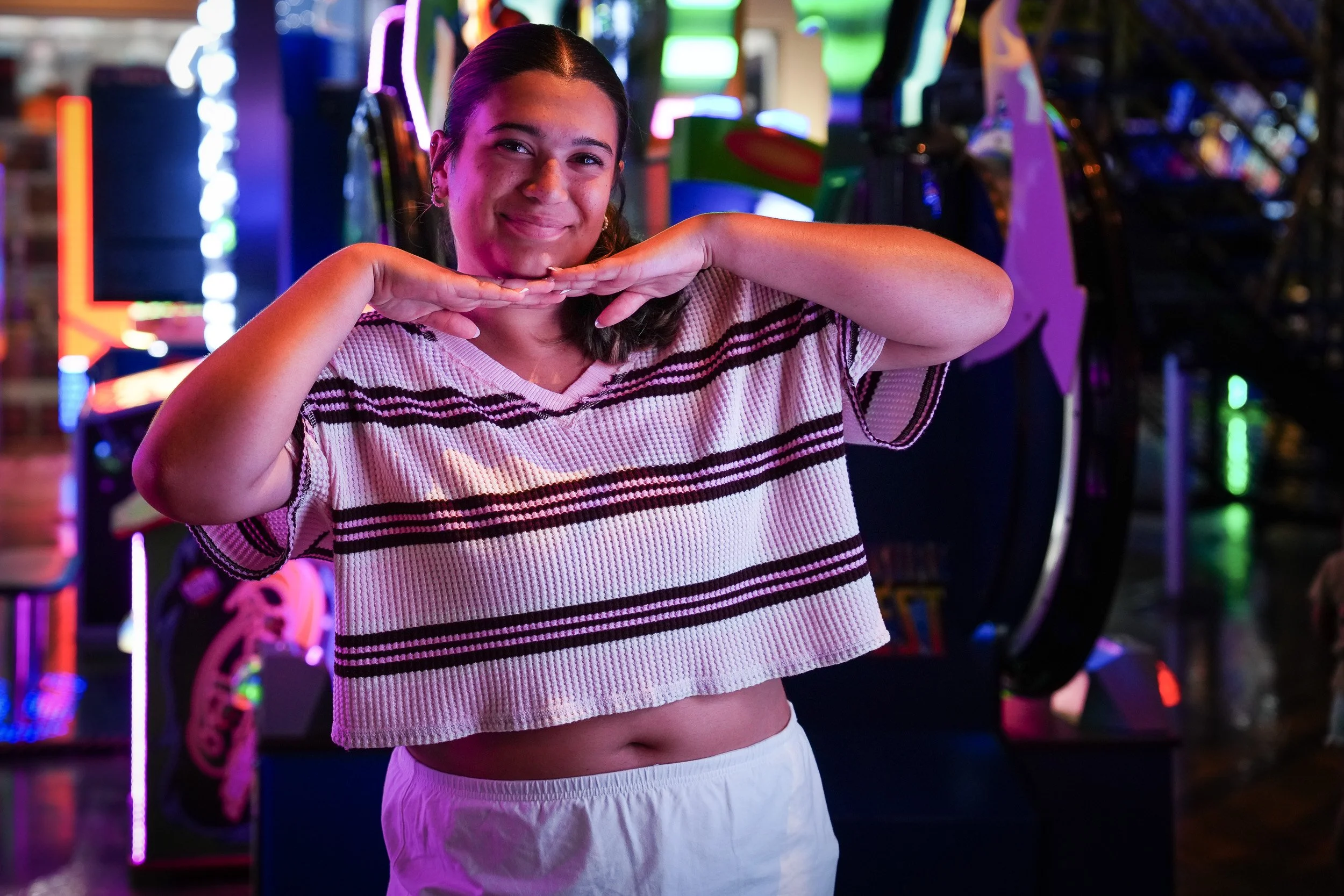 Teenage girl framed by arcade neon at night, night portrait photographer Fort Mill SC