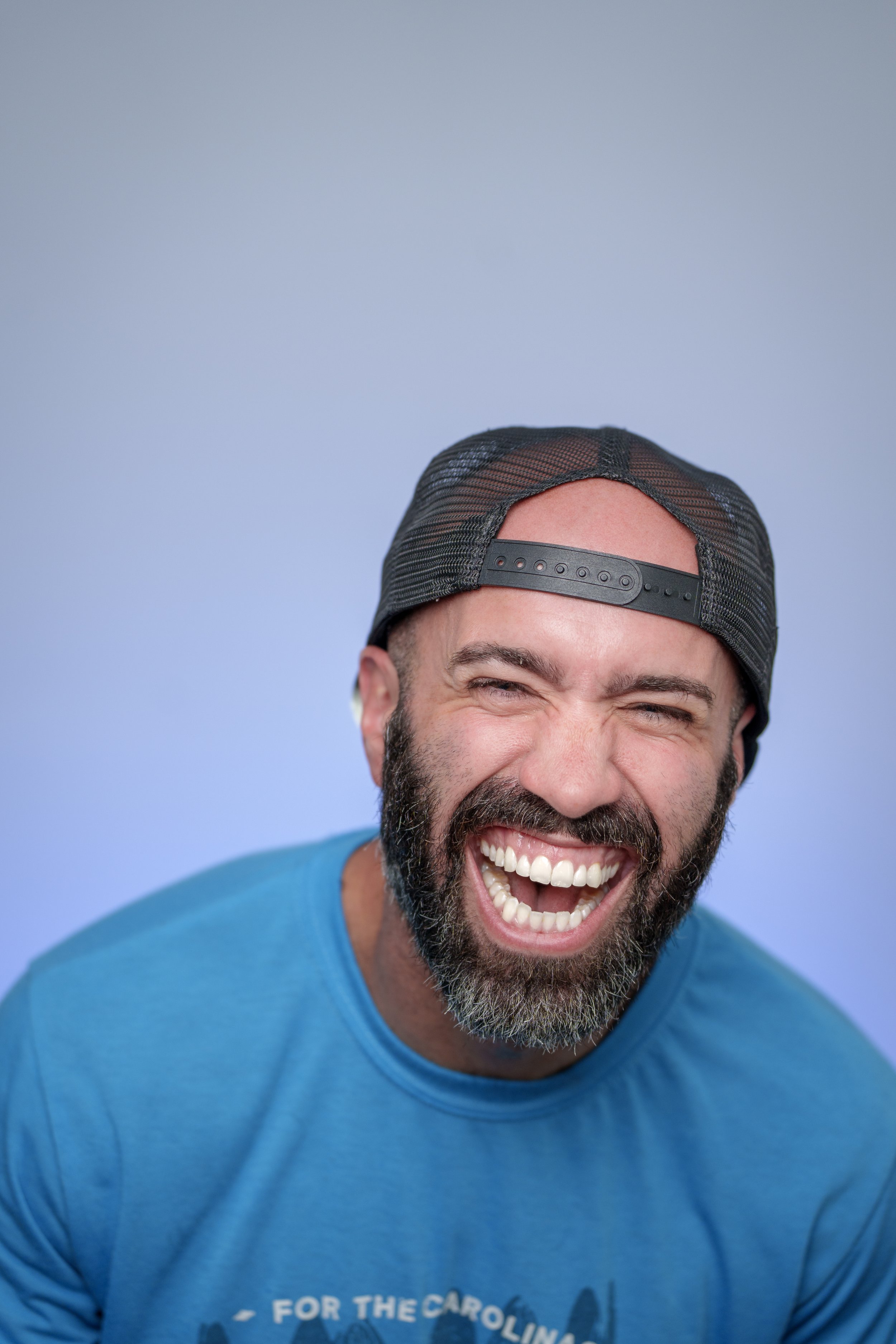 Photographer David Pesa laughing in a backwards cap, portrait taken by his daughter Ana Rehman