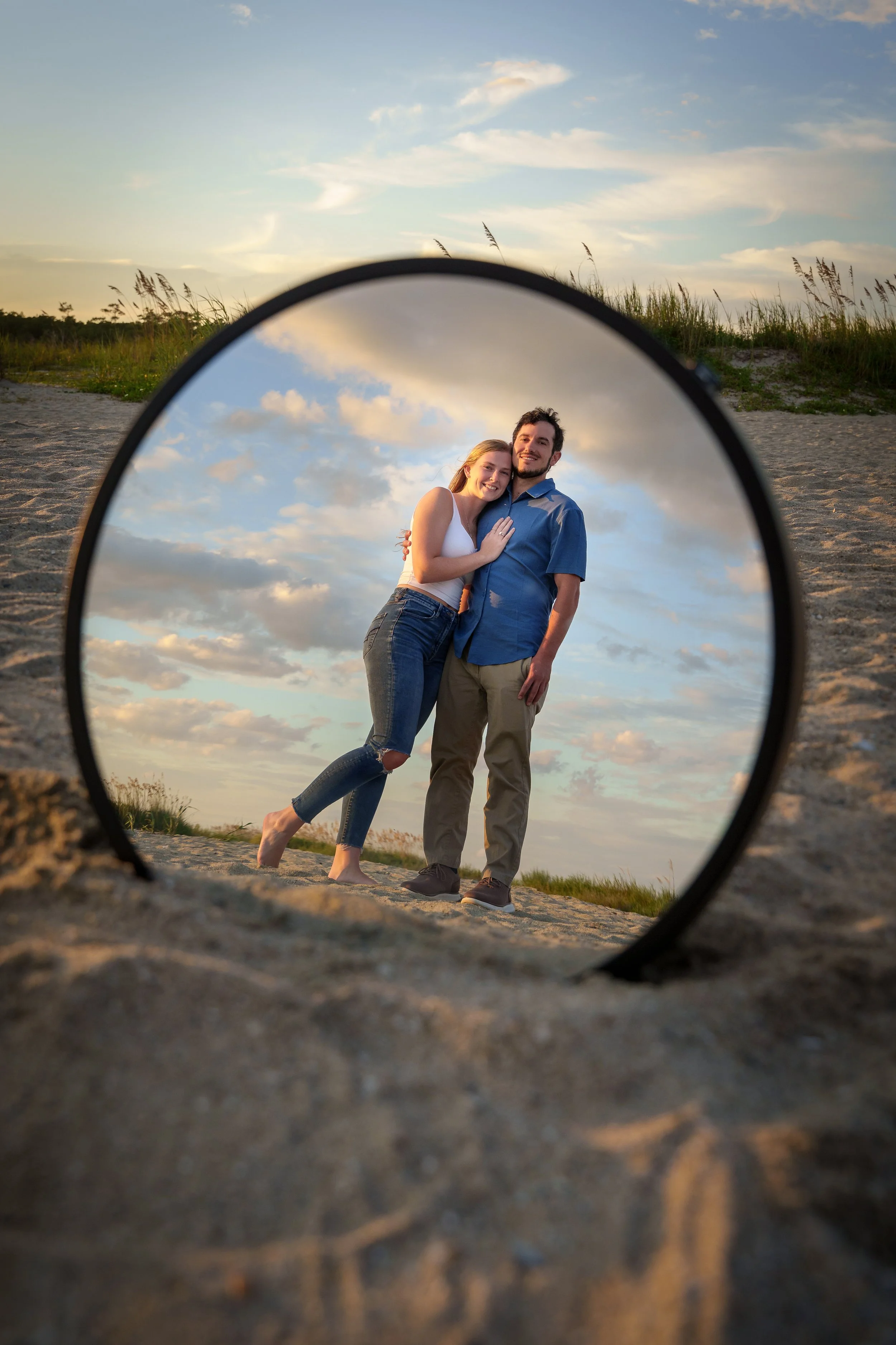 Couple reflected in a circular reflector on the beach, creative couples photographer Fort Mill