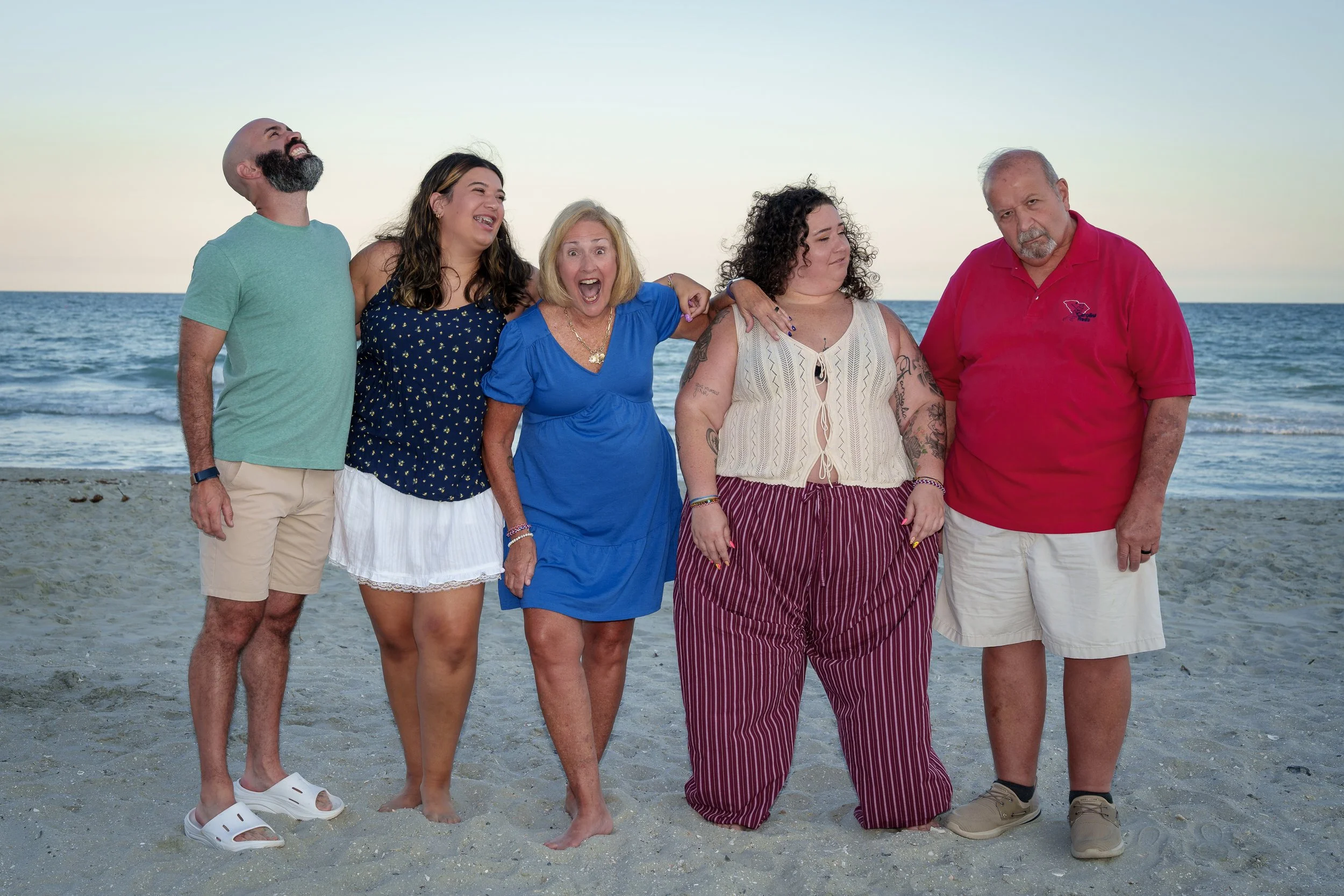 Family of five relaxed and laughing on the beach at dusk, family photography session South Carolina